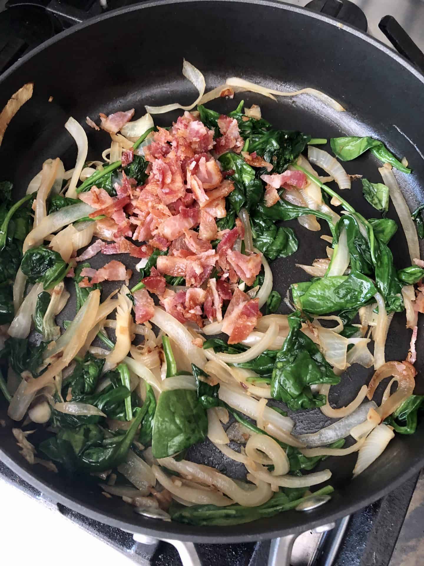 Bacon added to cooked spinach and onions