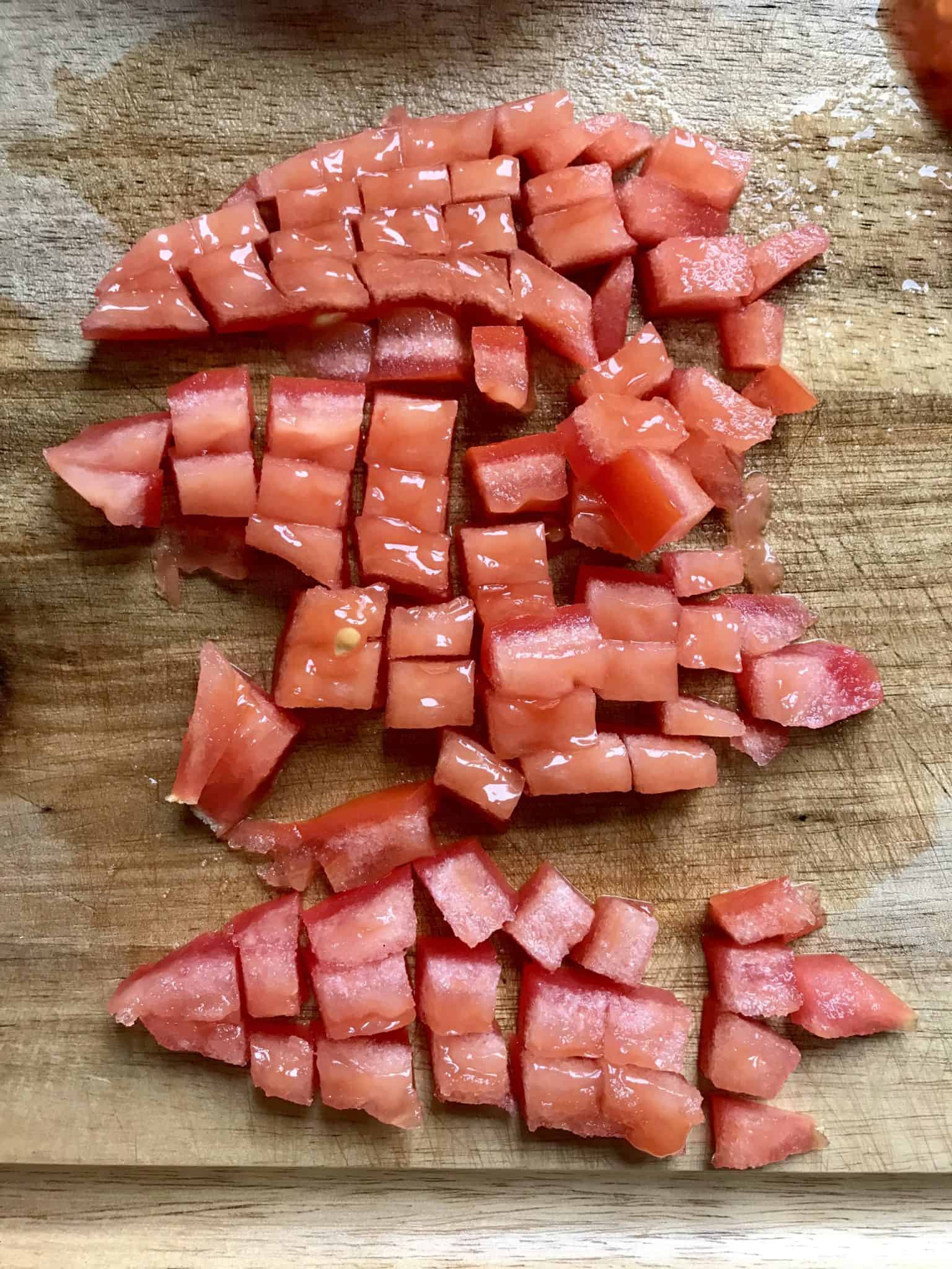 Diced tomato on wooden cutting board