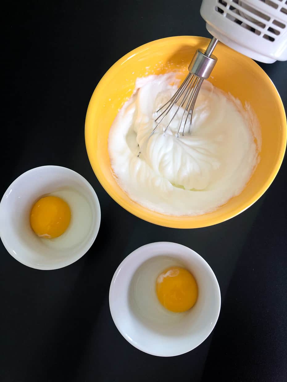 Egg whites being whipped in yellow bowl overhead shot