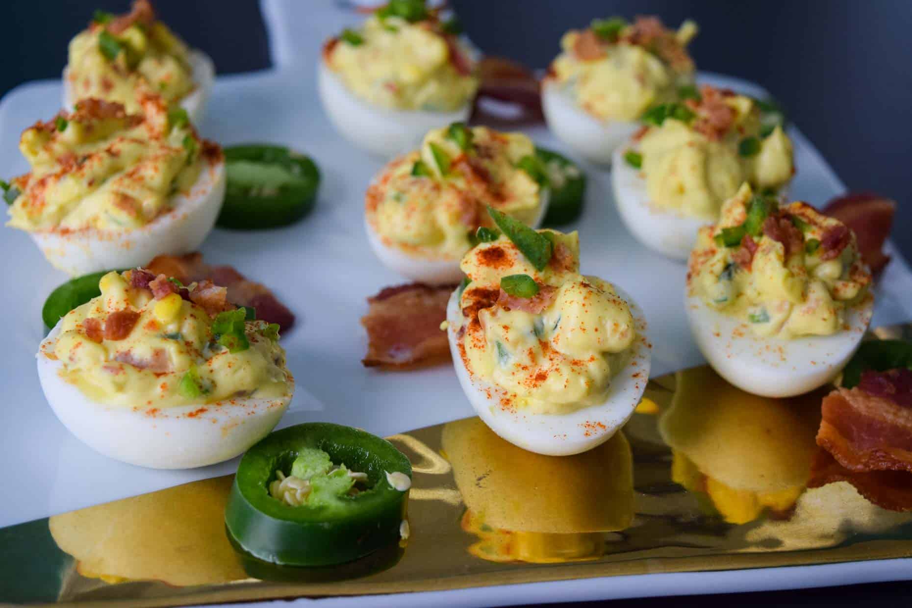 Jalapeno Bacon Deviled Eggs on white and gold platter side view