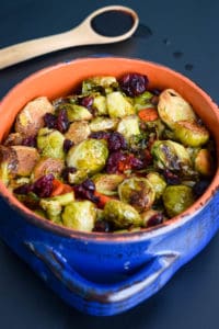 balsamic roasted Brussels sprouts with carrots and dried cranberries in blue and orange bowl