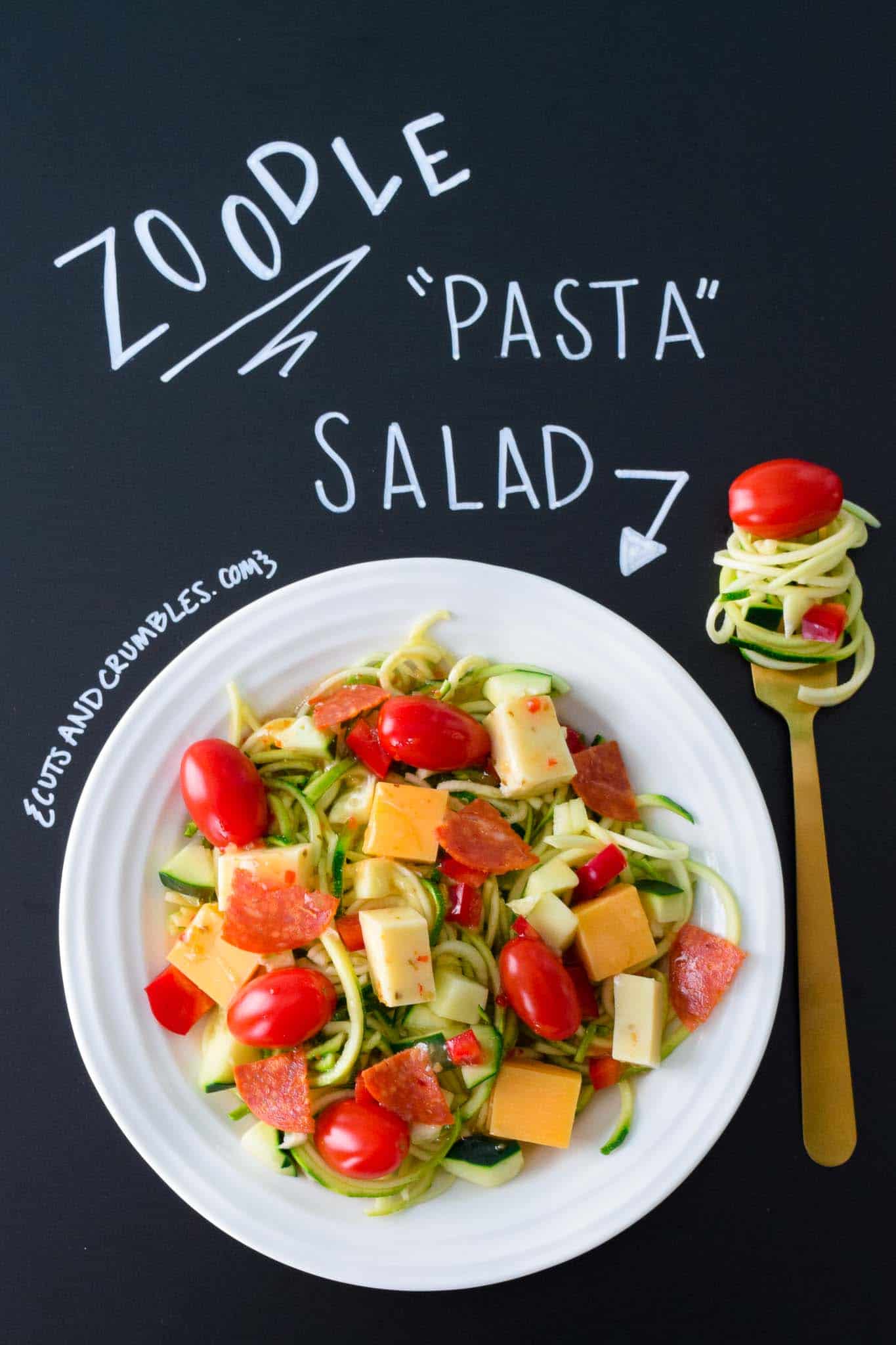 Zoodle Pasta Salad in white bowl with title written on chalkboard