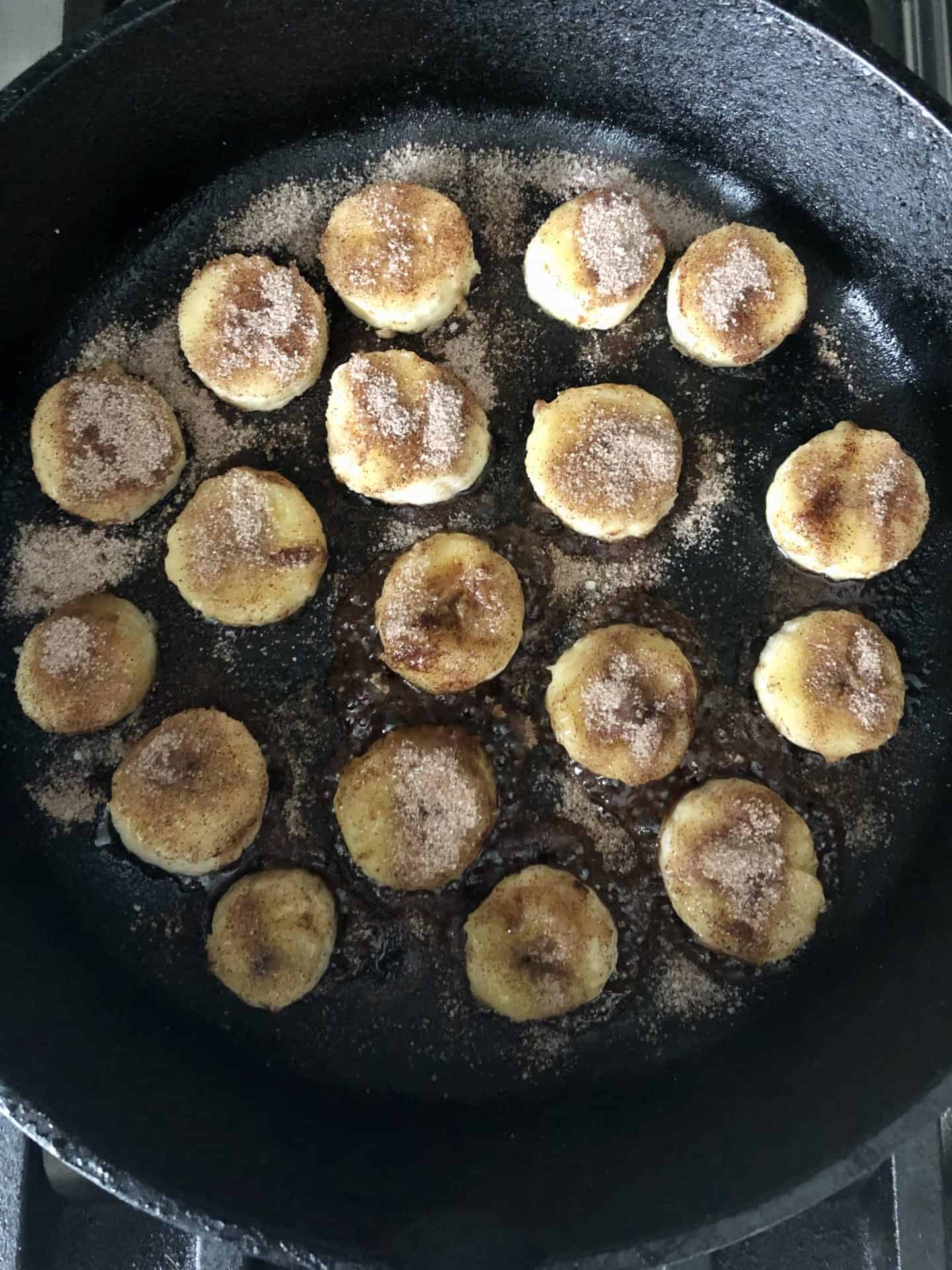 Bananas cooking in cast iron pan overhead shot