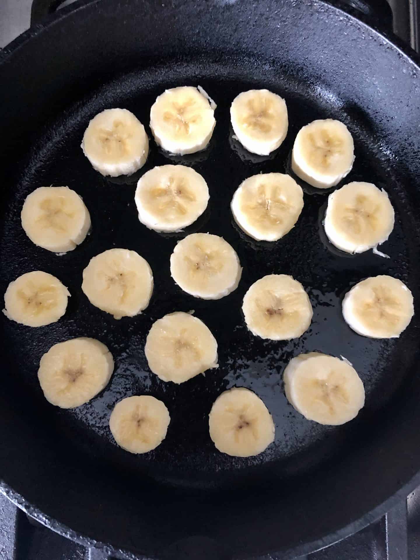 Cast iron pan with bananas being cooked overhead shot