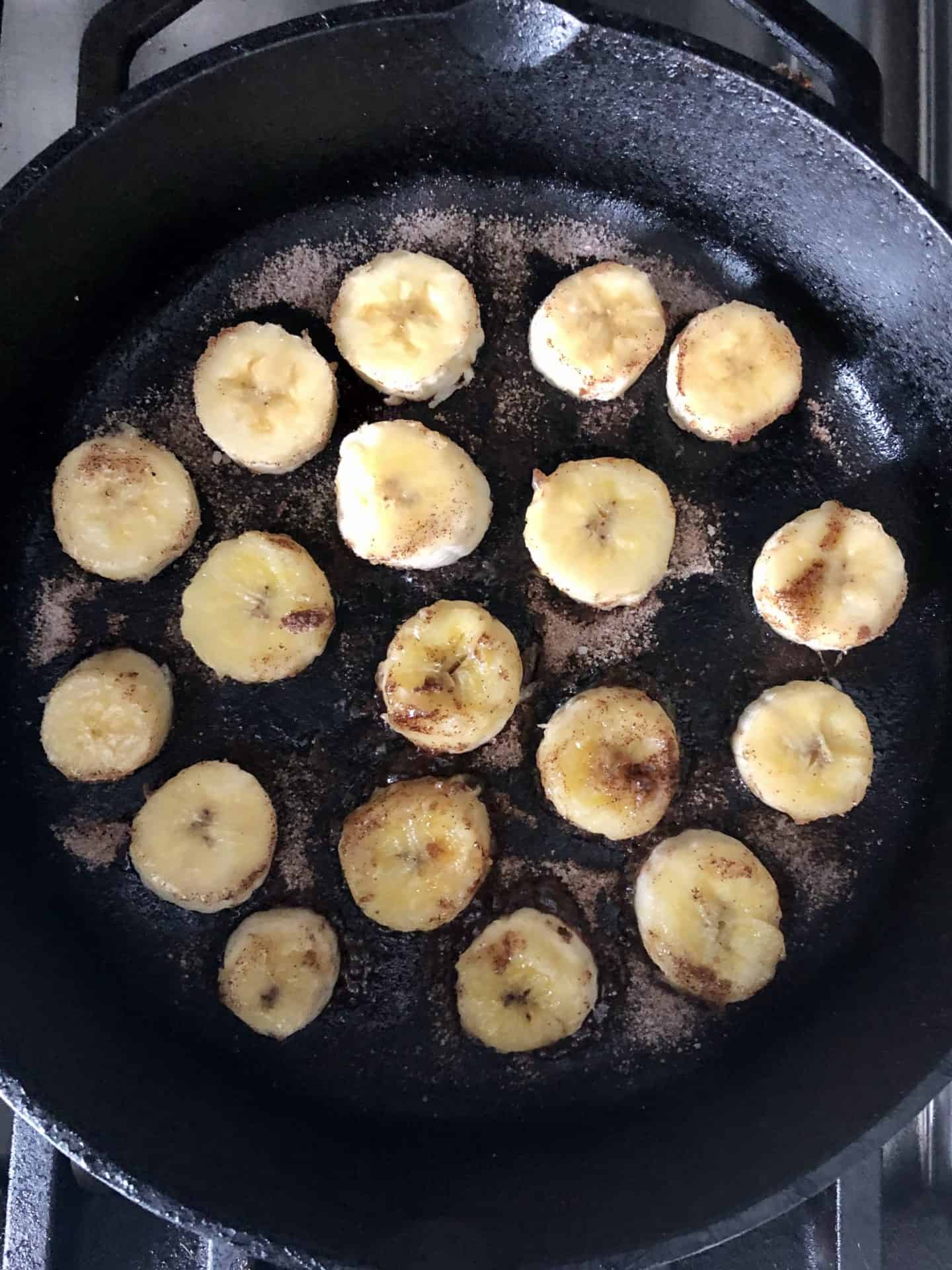 Bananas cooking in cast iron pan overhead shot