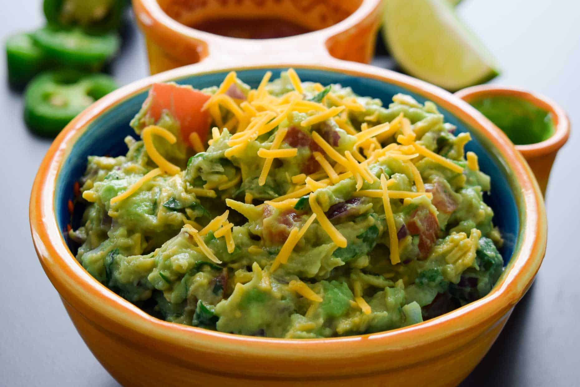 Cheesy Guacamole served in Mexican dish side view