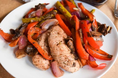 balsamic chicken and veggies on white plate close up view