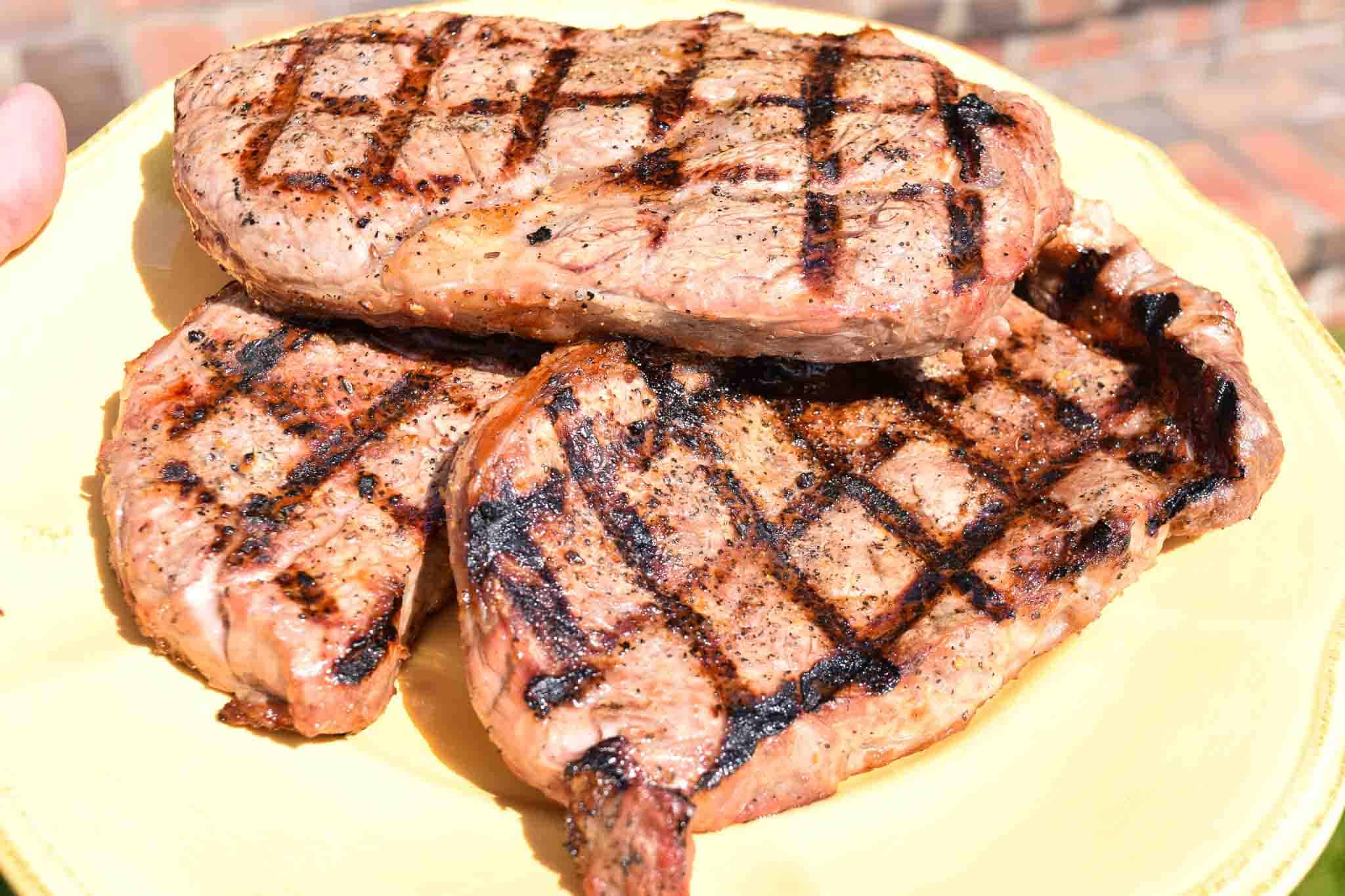 Steaks stacked up on yellow plate ready to be served
