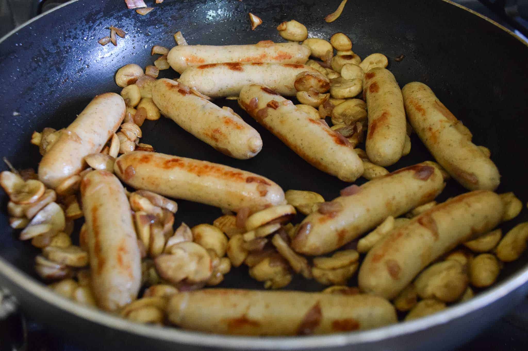 chicken sausage and mushrooms frying in pan
