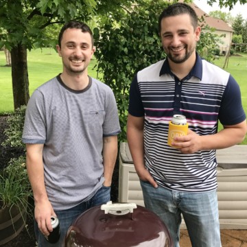 The BBQ Brothers standing by a weber grill