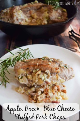 apple bacon blue cheese stuffed pork chops on white plate with sprig of rosemary and title