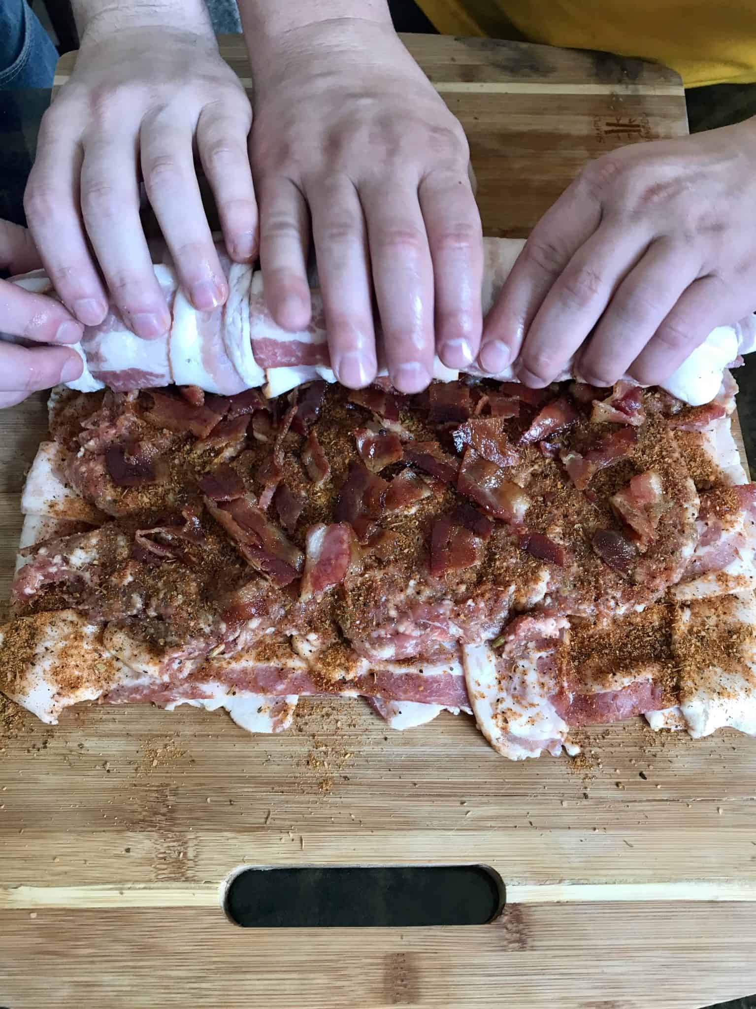 Bacon fatty being rolled up overhead shot