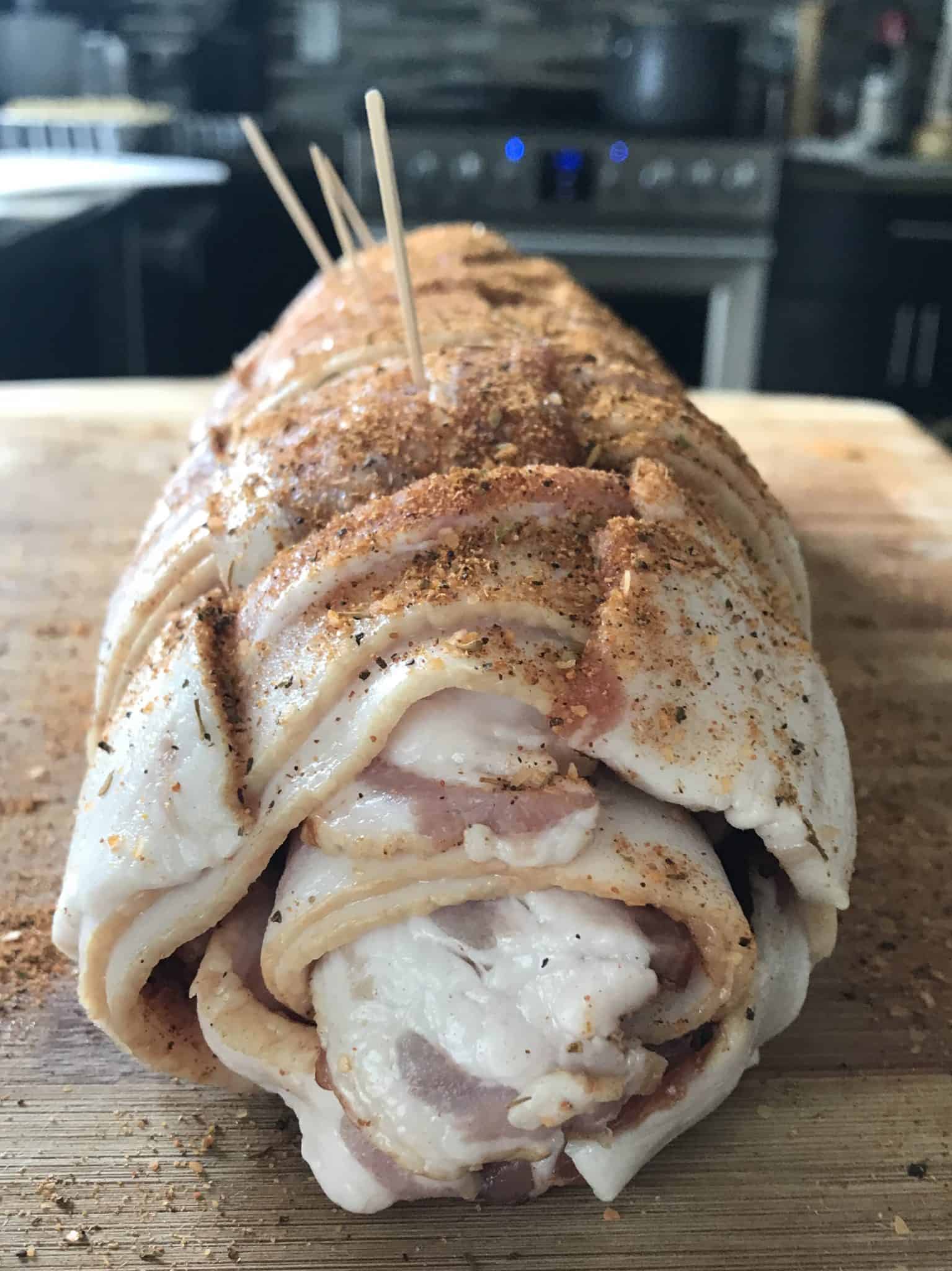 Bacon explosion rolled up with toothpicks holding it together side view