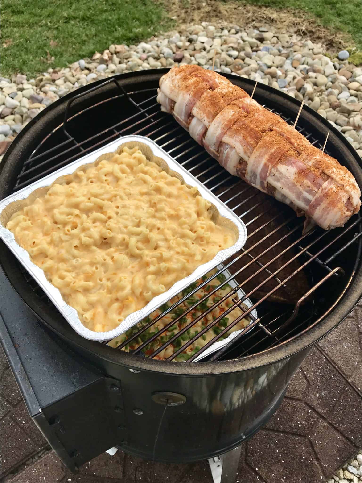 Bacon explosion on weber grill next to pan of smoked Mac and cheese 
