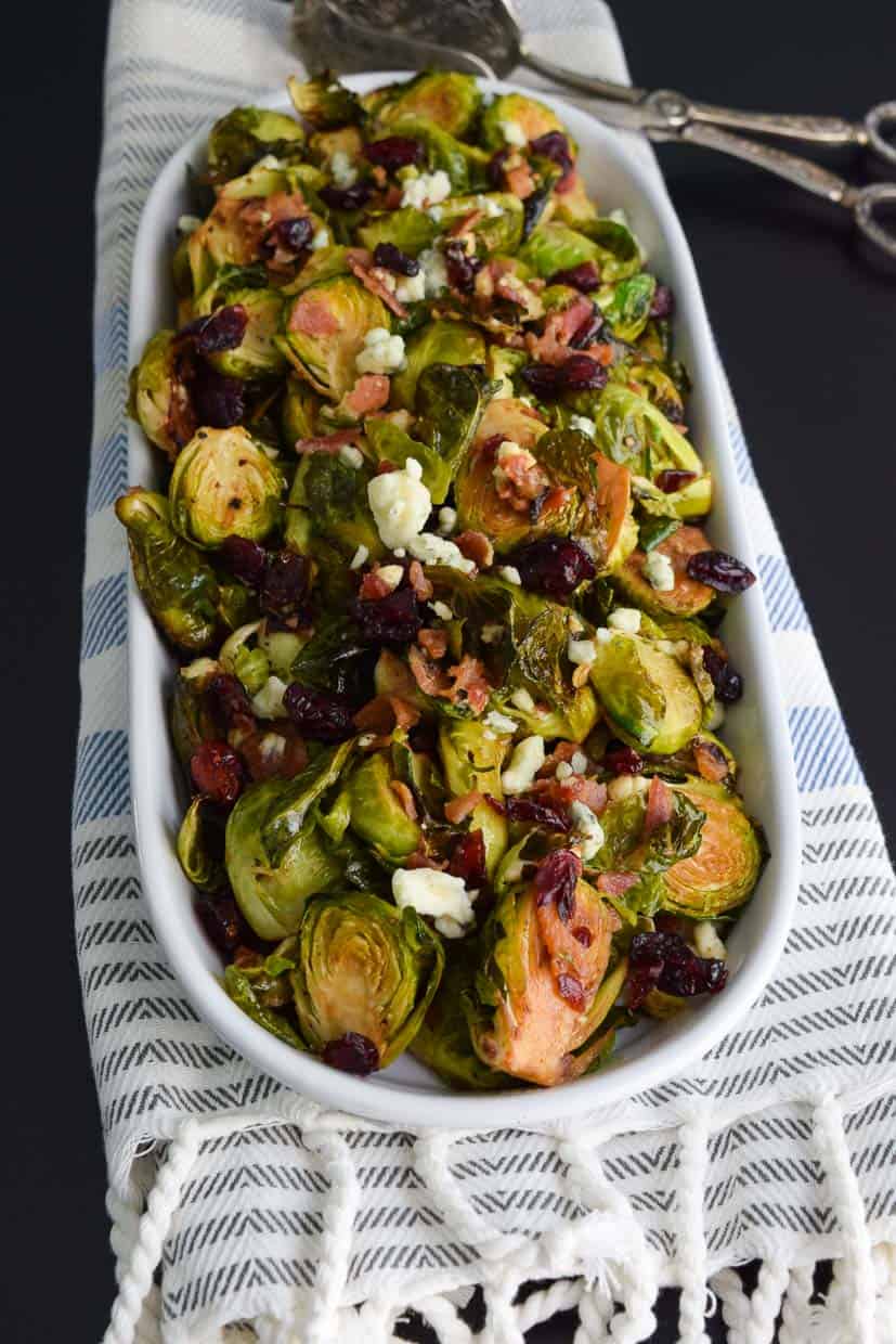 Brussels Sprouts with Bacon and Blue Cheese in platter on striped towel ready to be served