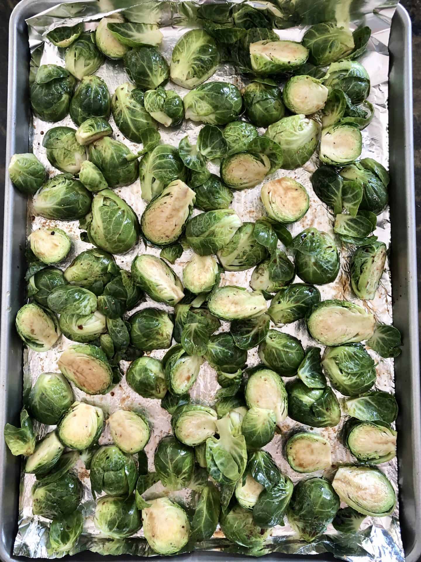 Brussels sprouts on baking sheet ready to be roasted