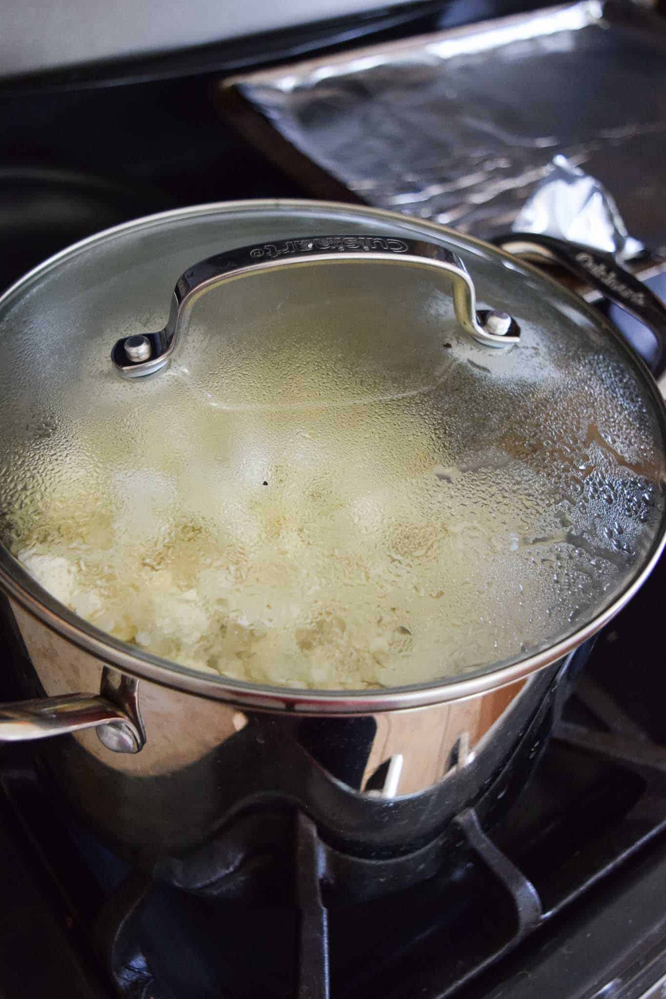 Cauliflower steaming in covered pot on stove 