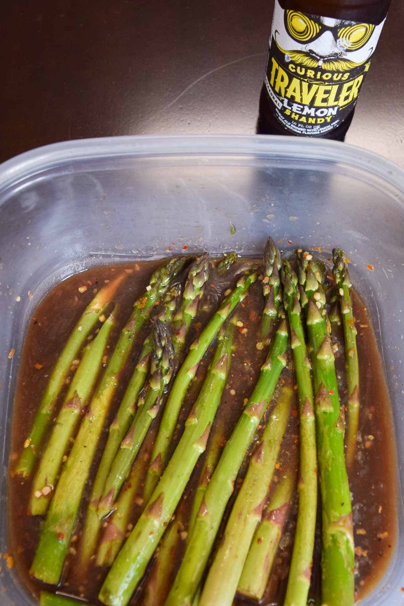 Asparagus marinating in Tupperware container
