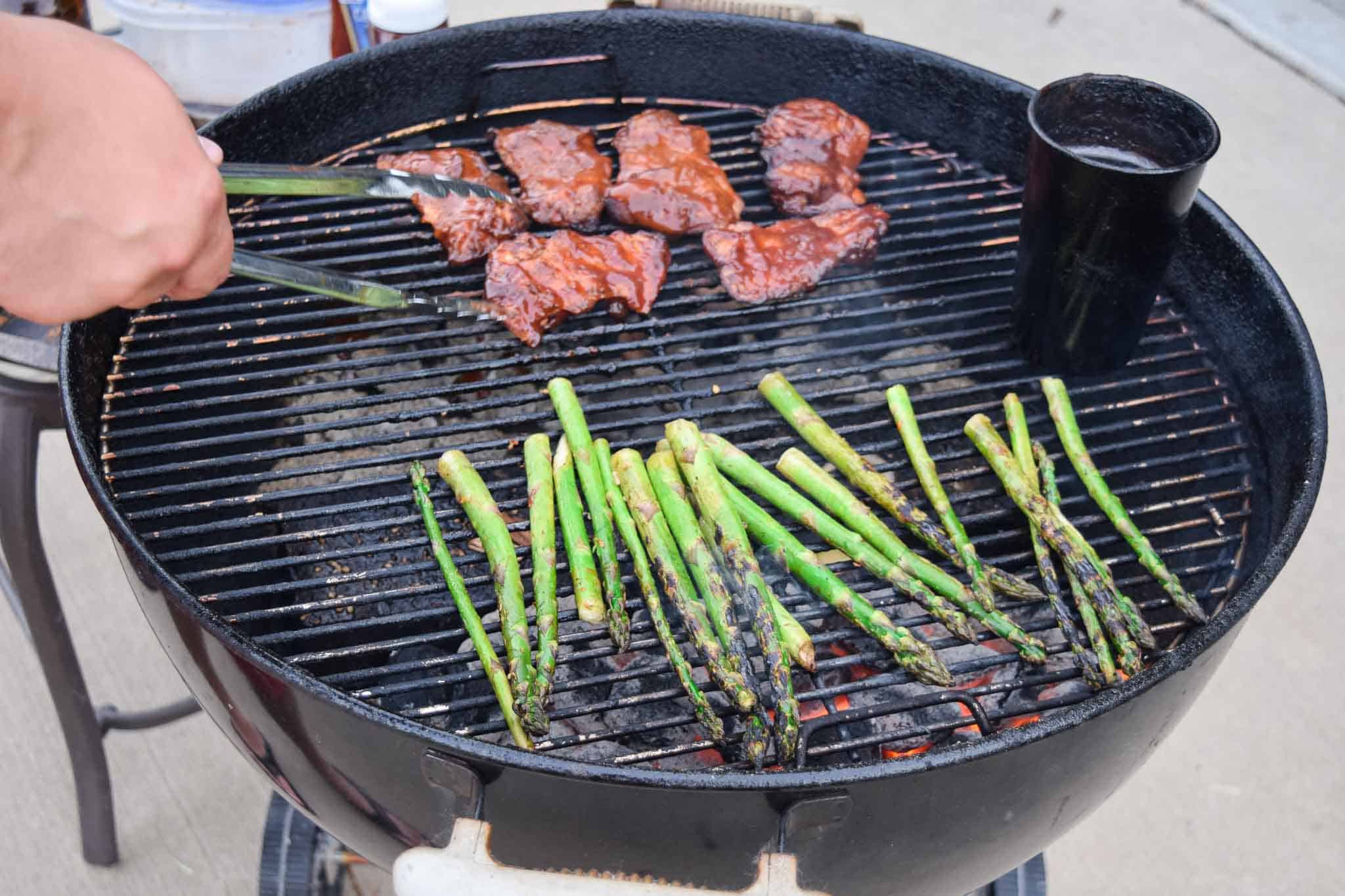chicken thighs and asparagus on weber grill side view