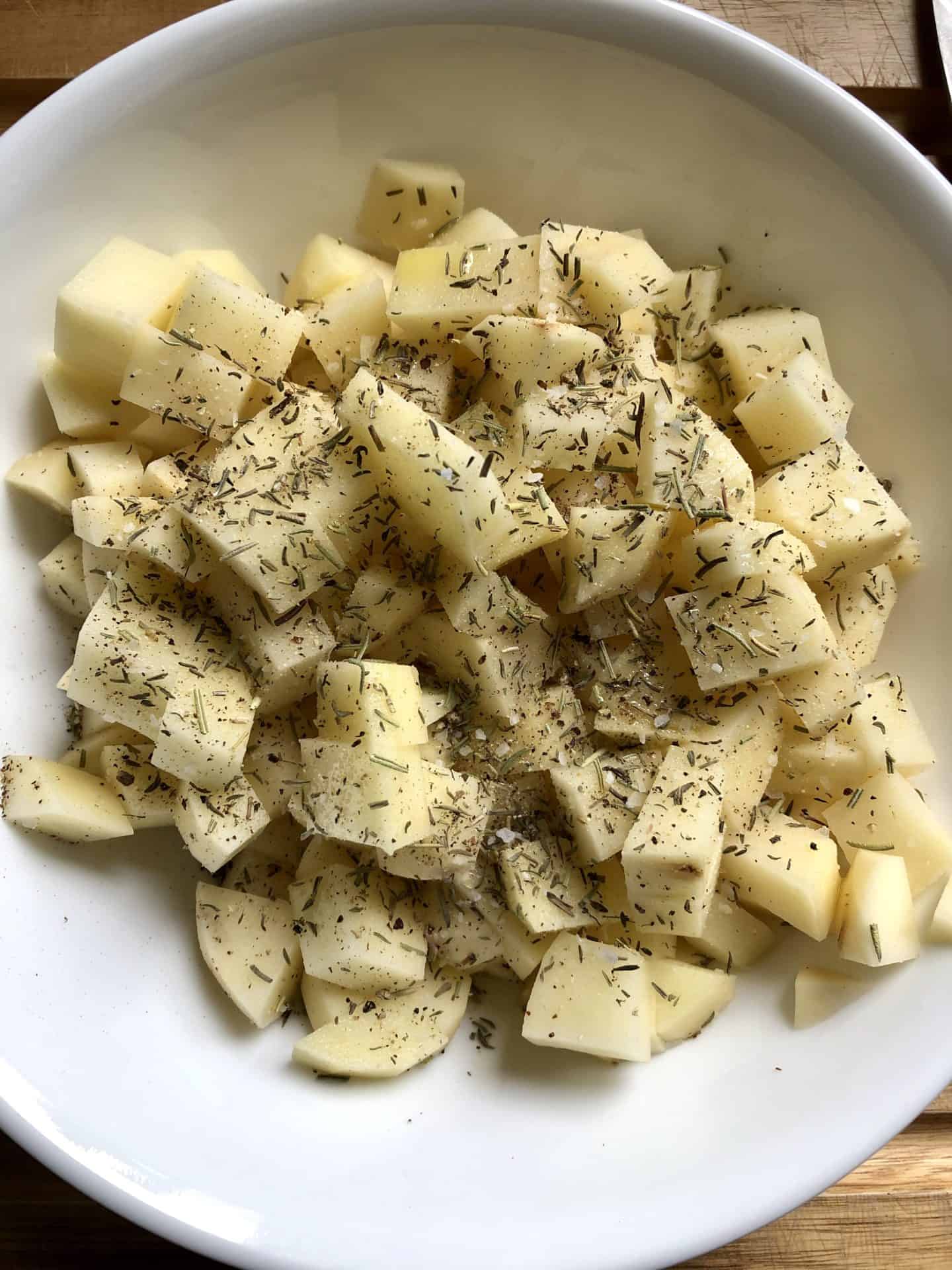 diced potatoes in bowl with seasonings