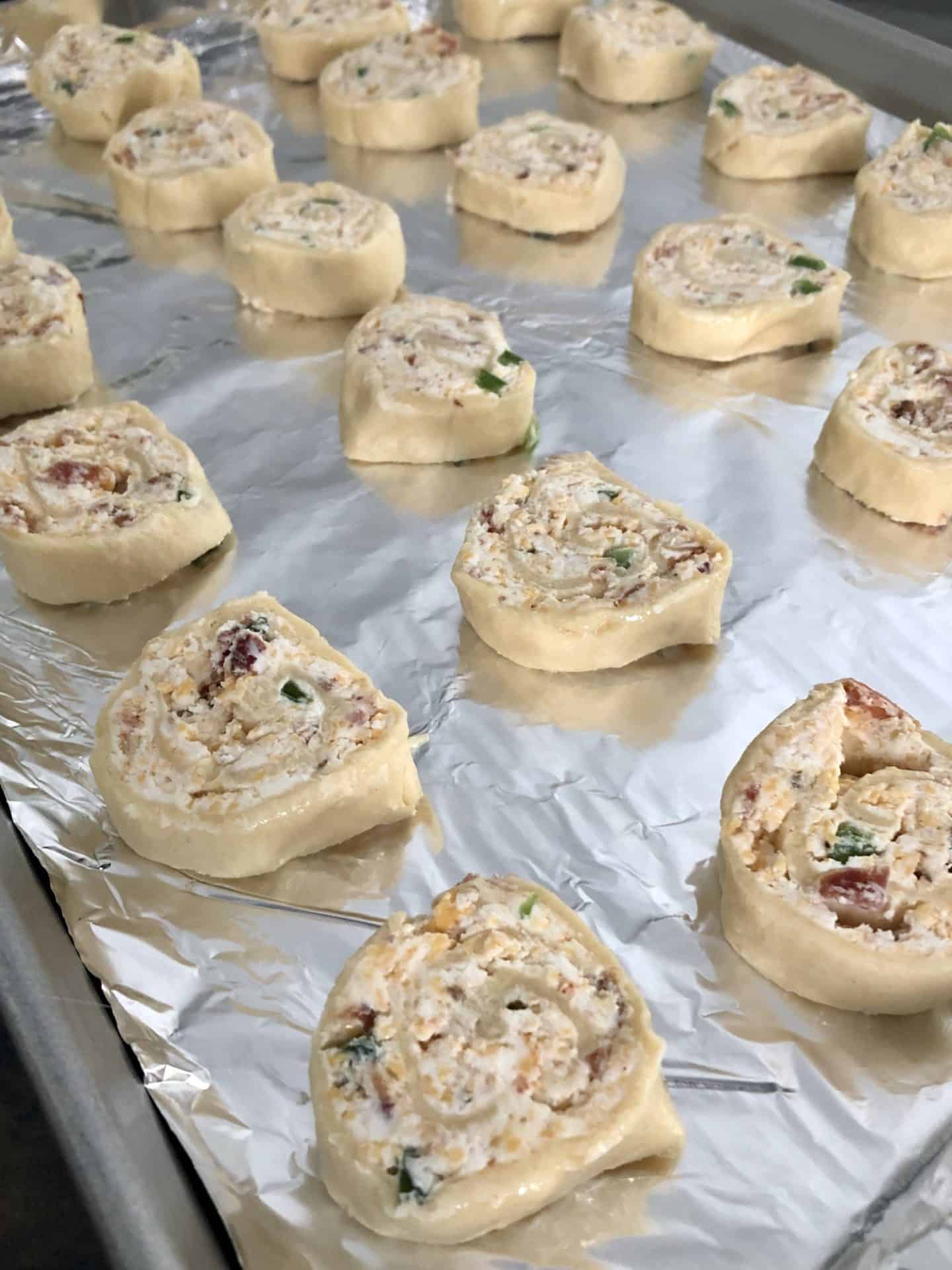 Cheddar Bacon Jalapeño Pinwheels on foil lined baking sheet ready to be cooked