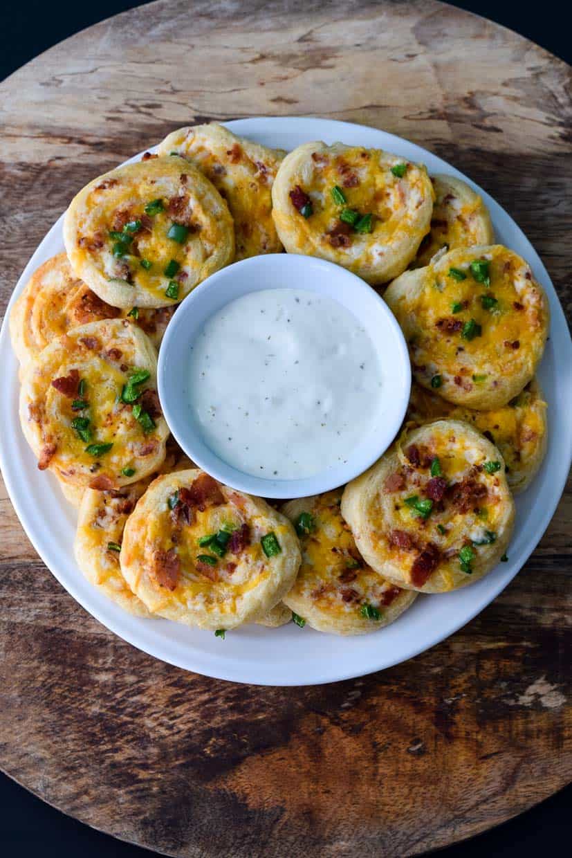 Cheddar Bacon Jalapeño Pinwheels on white platter with ranch in middle overhead shot