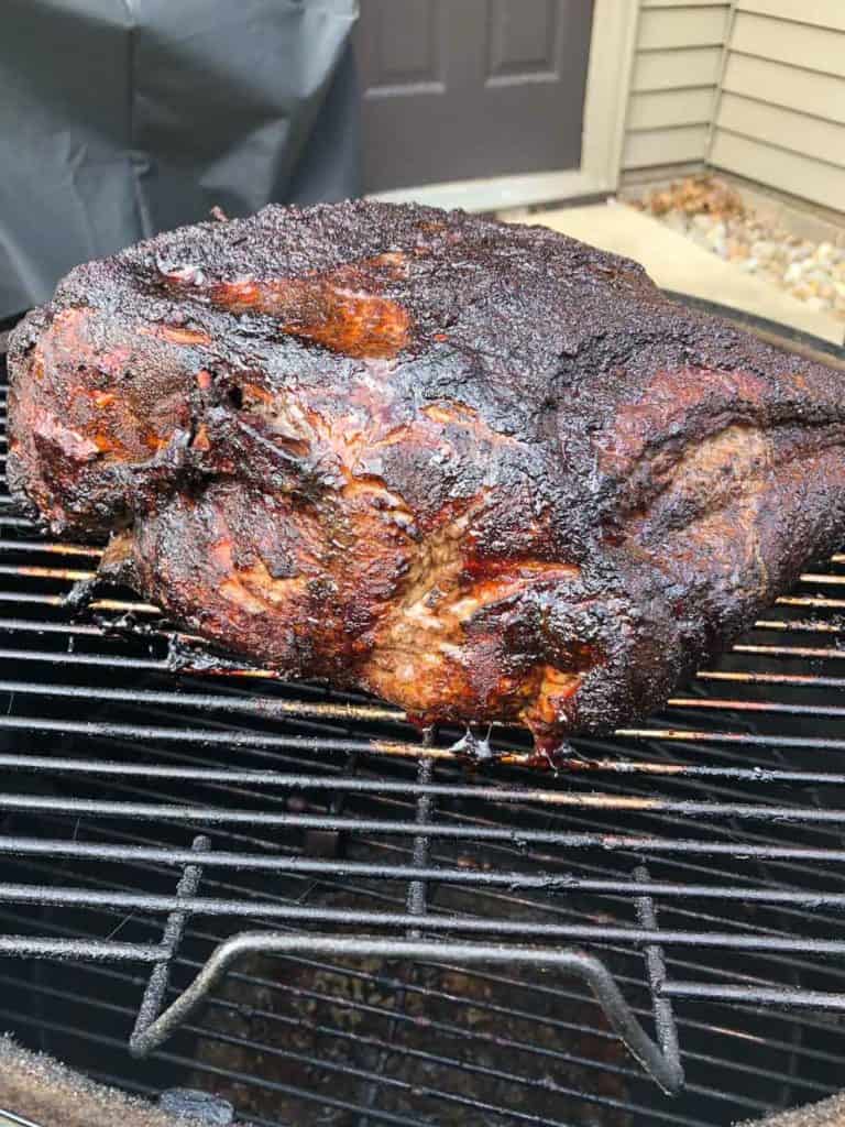 Side view of smoked pork butt on weber grill