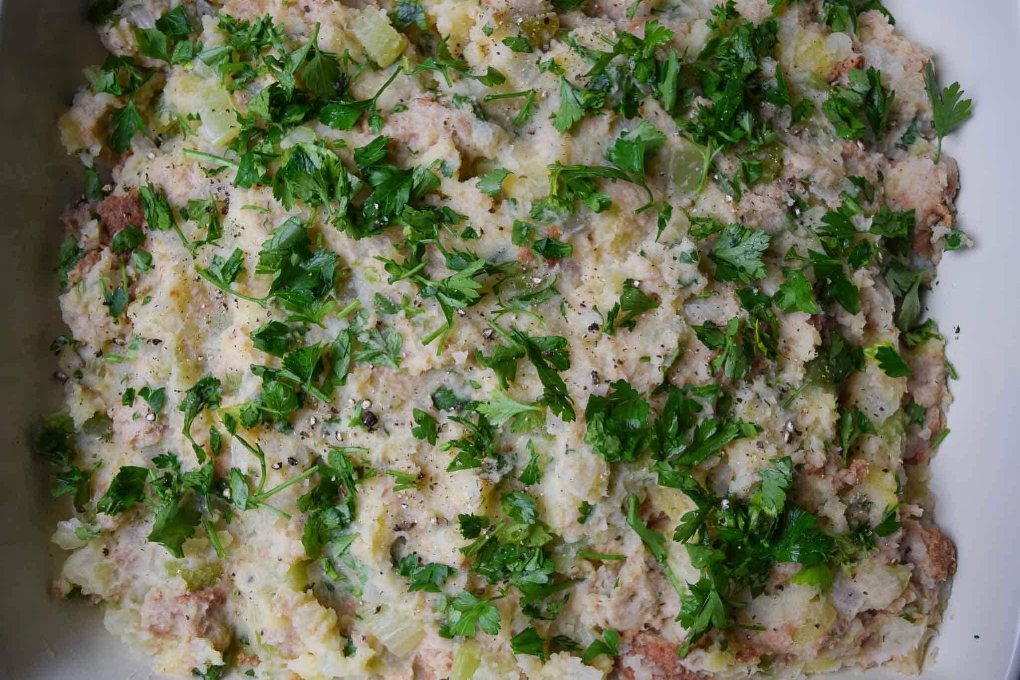 potato stuffing in 9x13 pan topped with parsley ready to be baked overhead shot