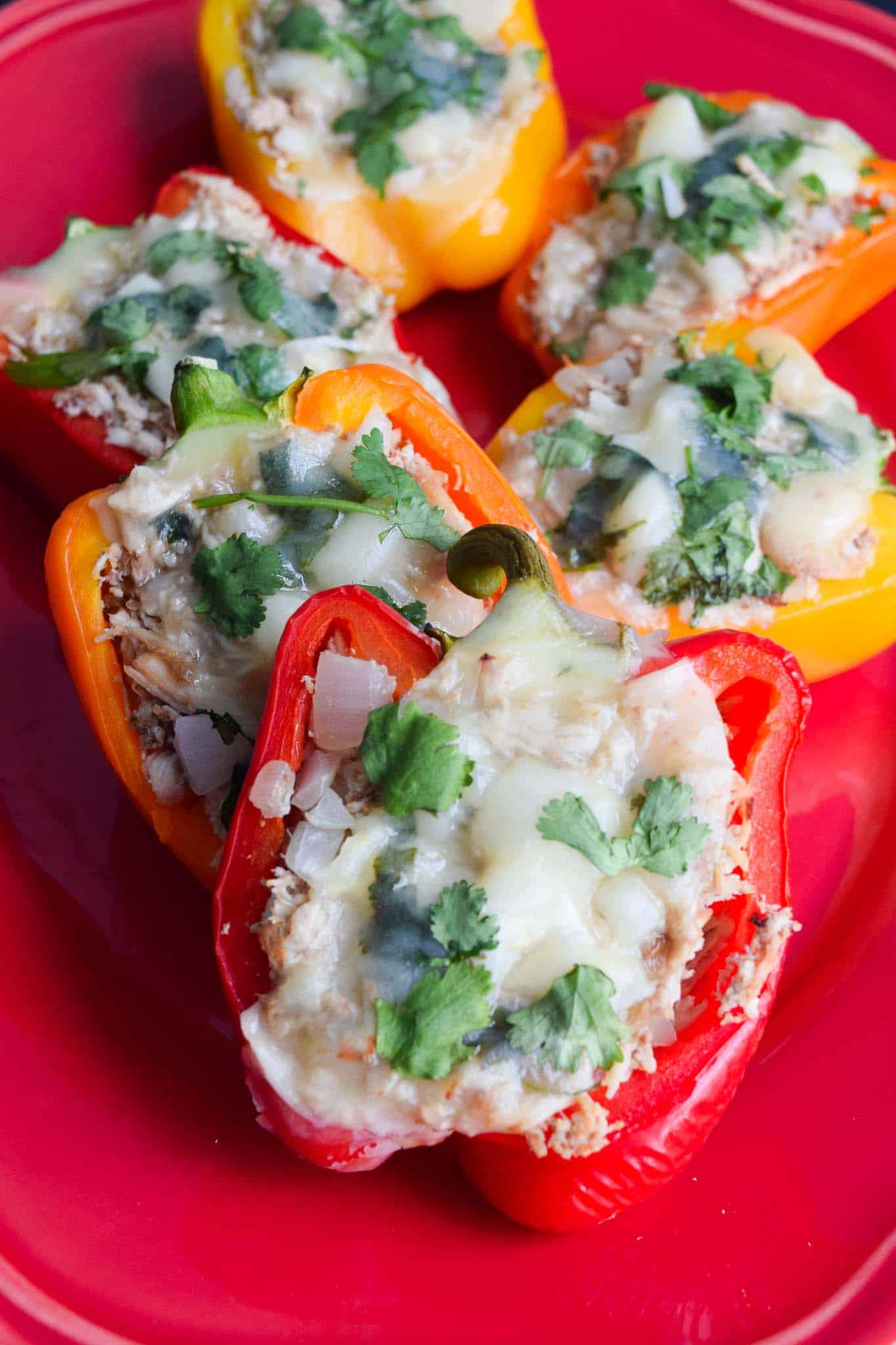 chicken stuffed peppers on red platter ready to be served