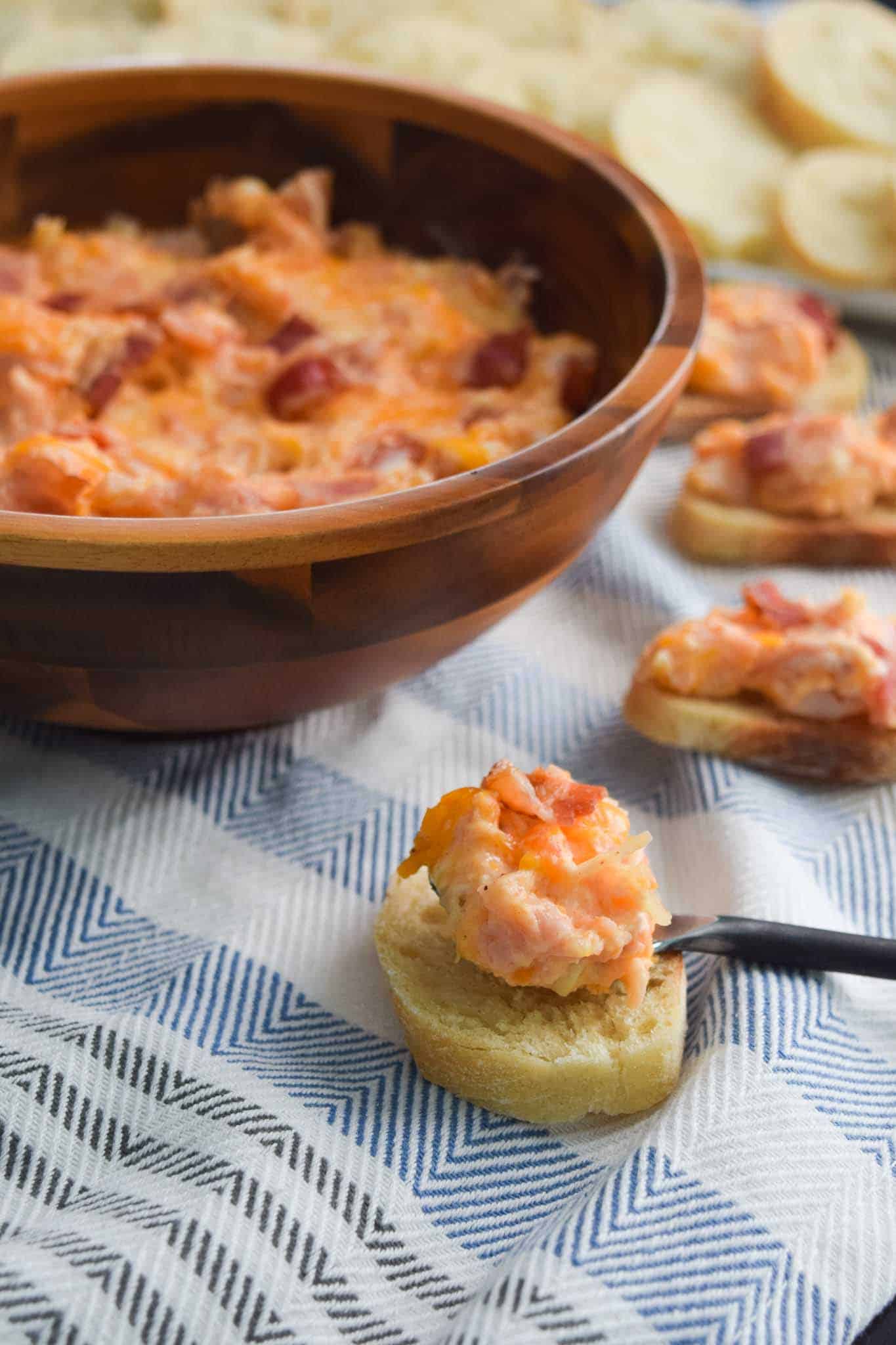 Kentucky Hot Brown Dip in bowl spooned onto crostini for serving