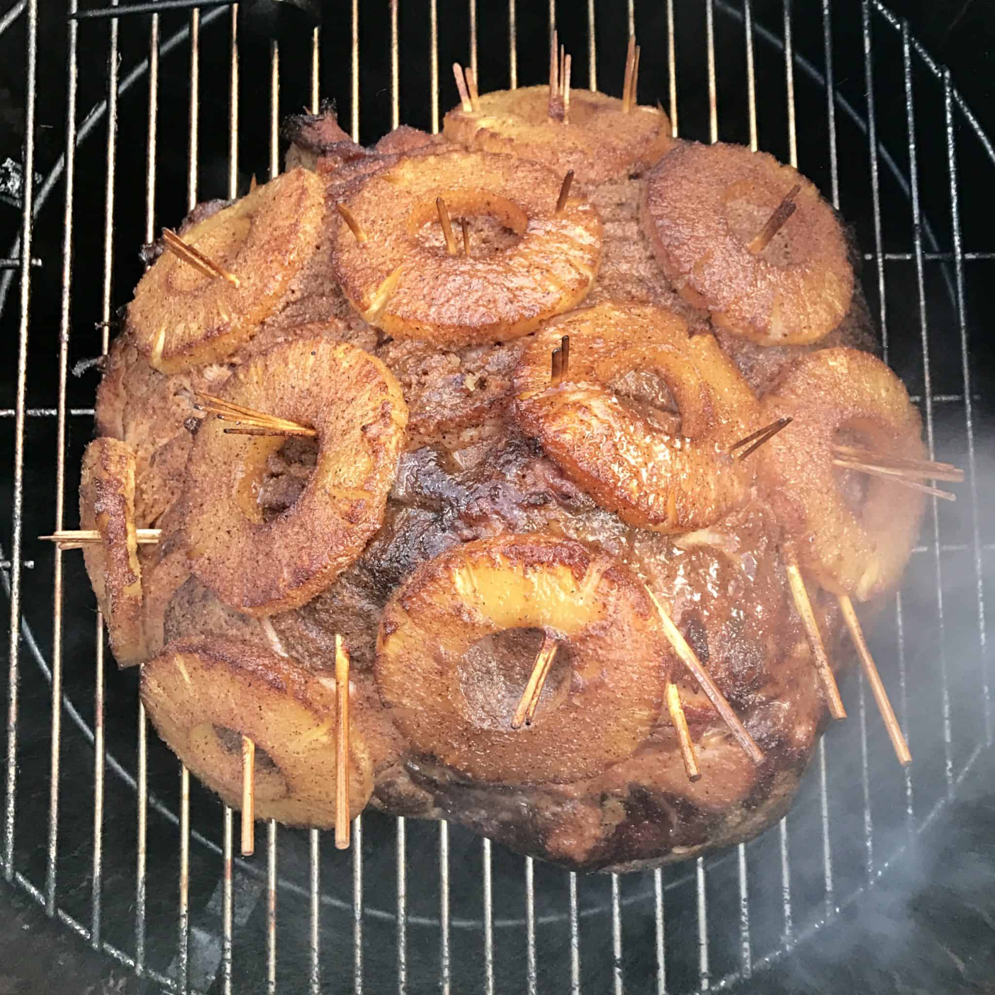 bbq smoked ham covered in pineapples on weber grill overhead shot