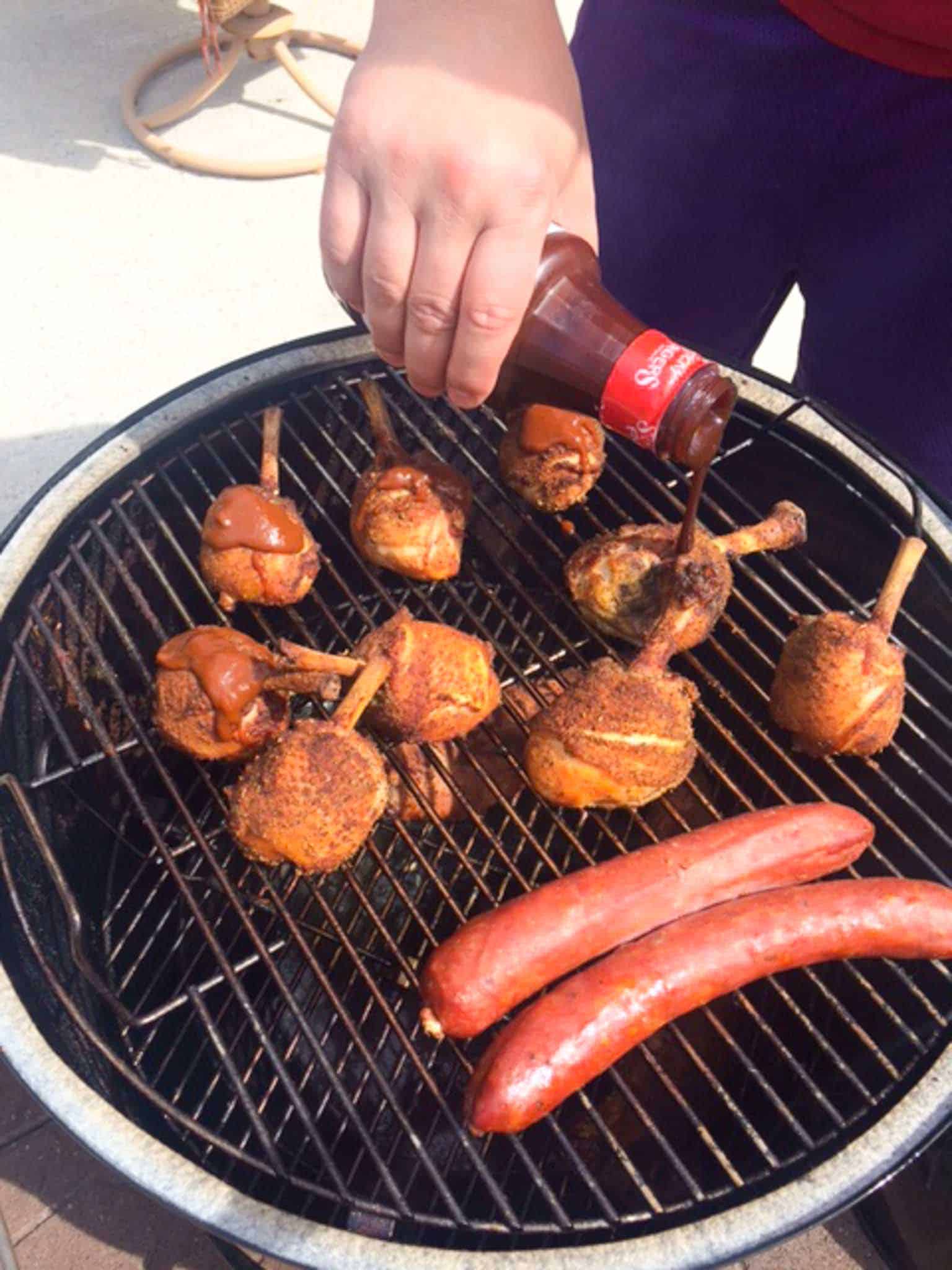 Chicken Lollipops being sauced on weber grill 