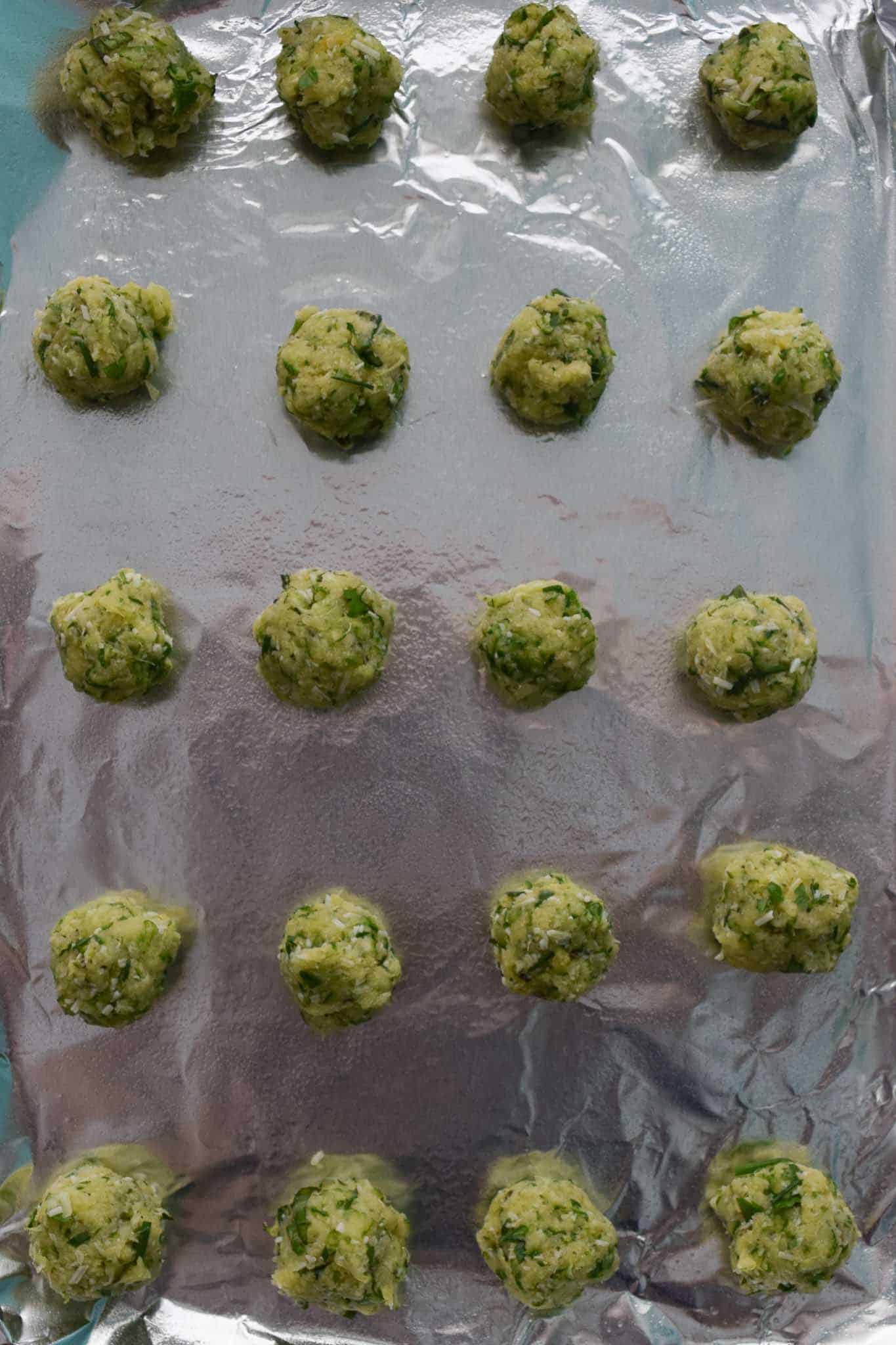 Zucchini Garlic and Herb Bites on baking sheet lined with foil overhead shot