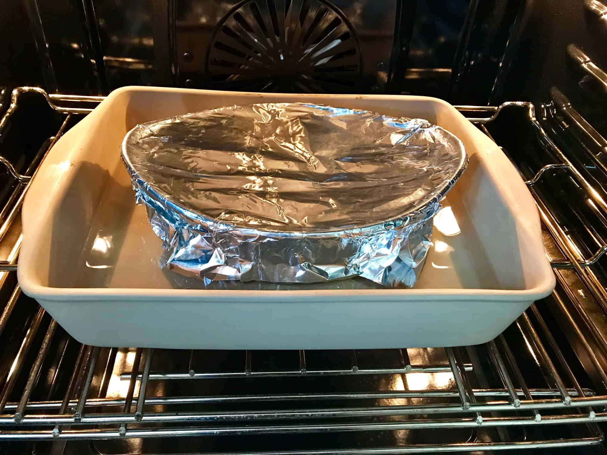 Pan covered in foil in pan full of water in oven 