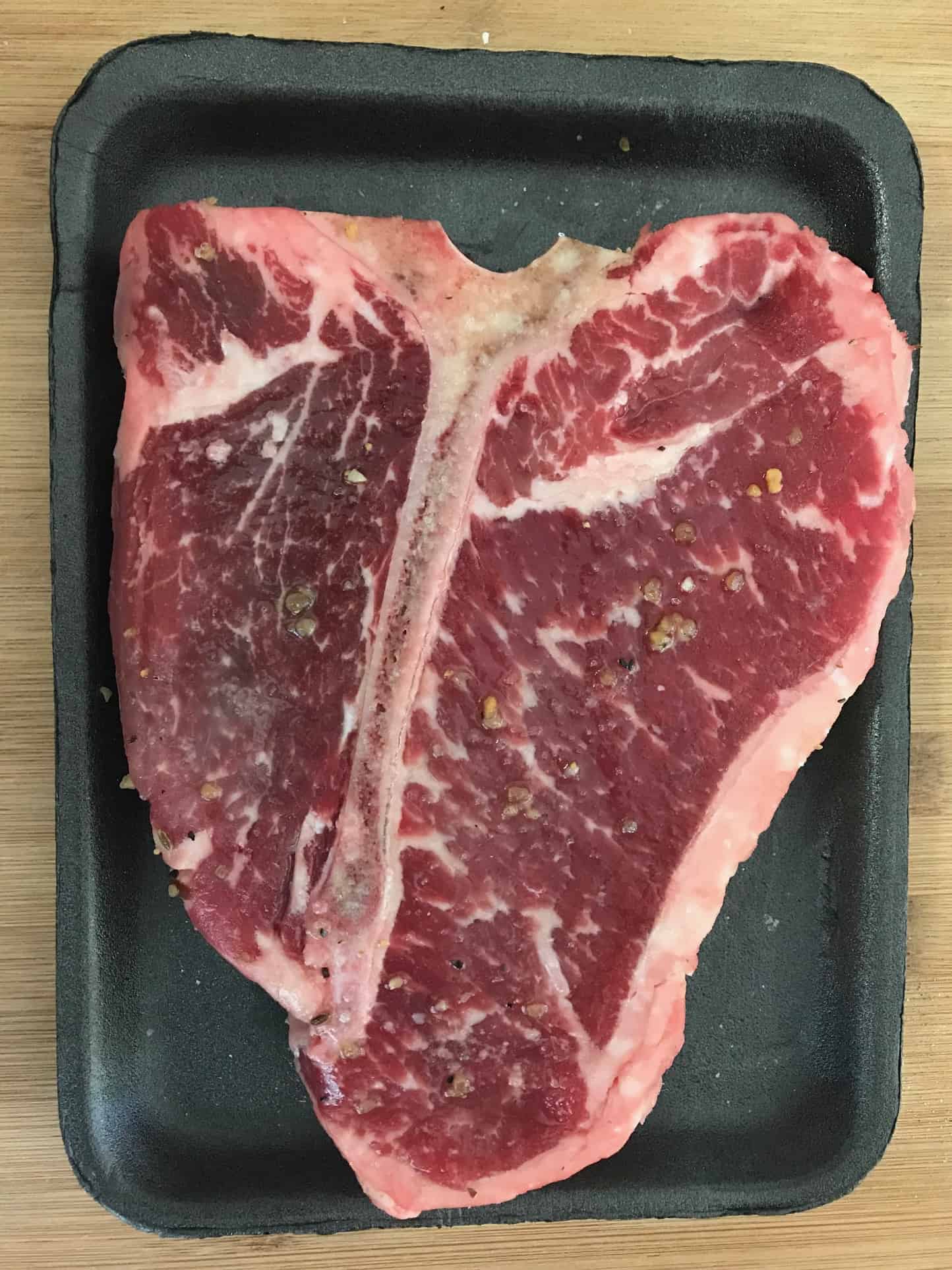 Raw steak in original packaging overhead shot
