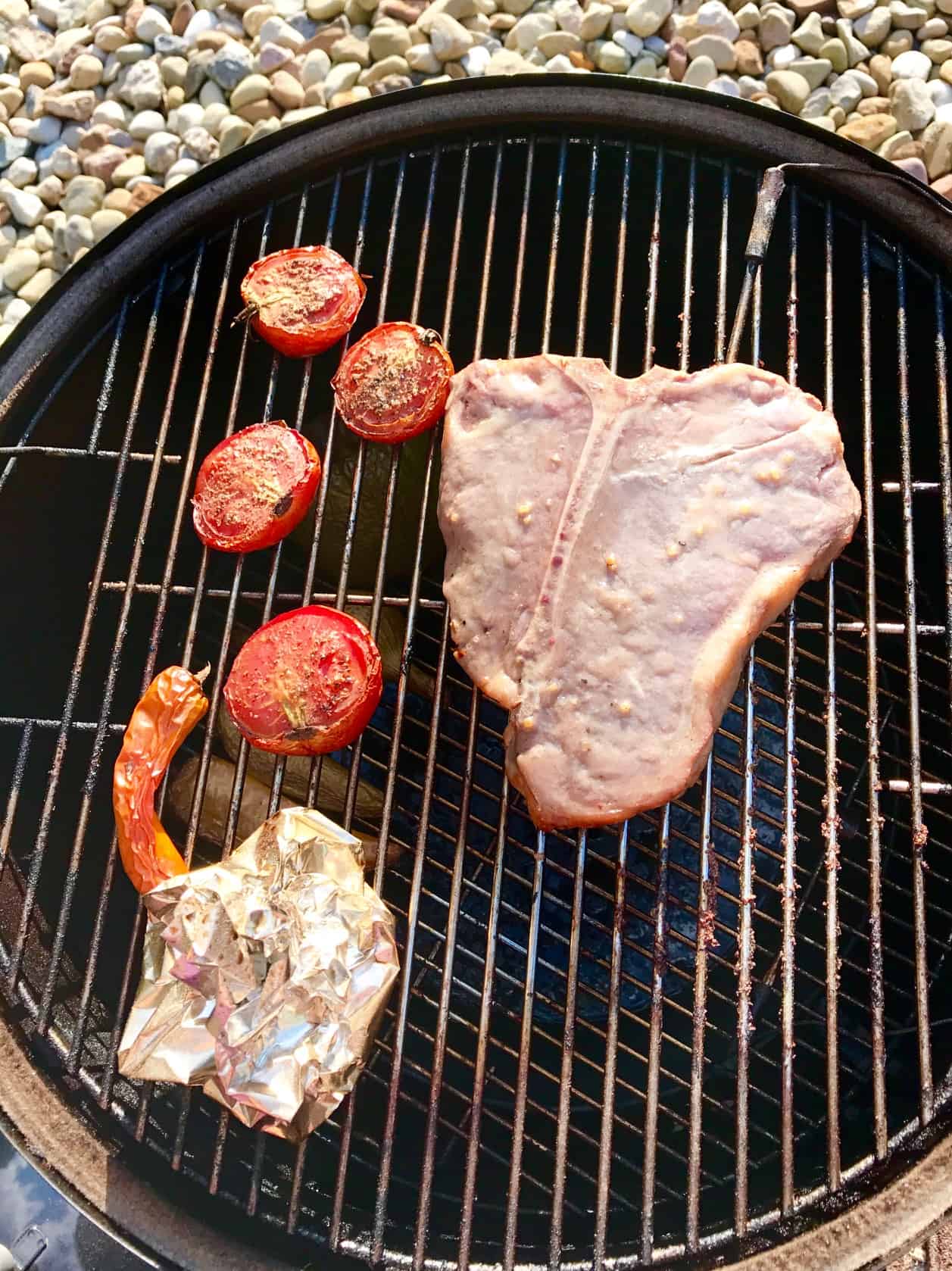 Steak with vegetables on weber grill overhead shot