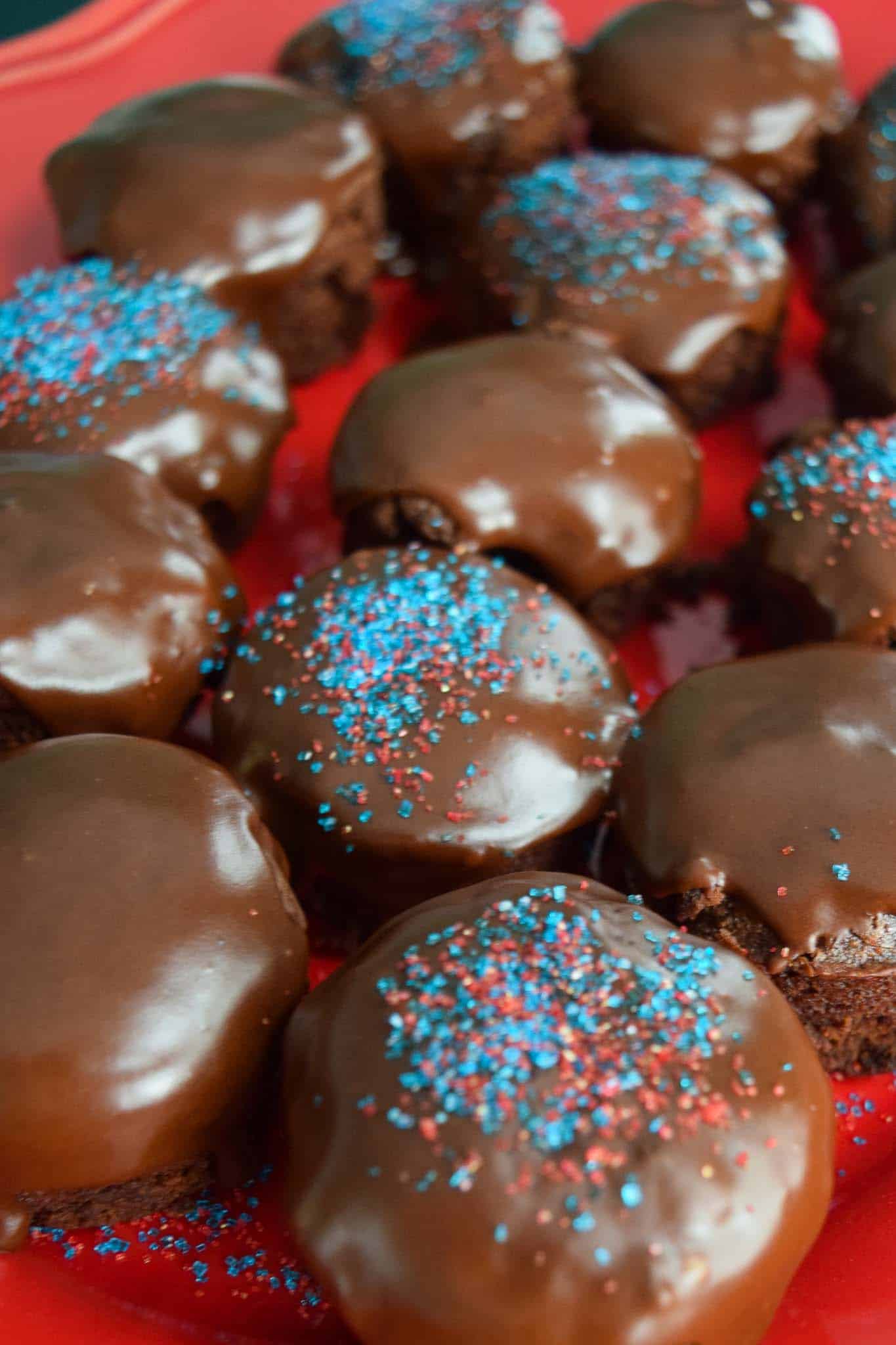 Chocolate Chip Brownie Bites with Homemade Icing topped with red and blue sprinkles close up view