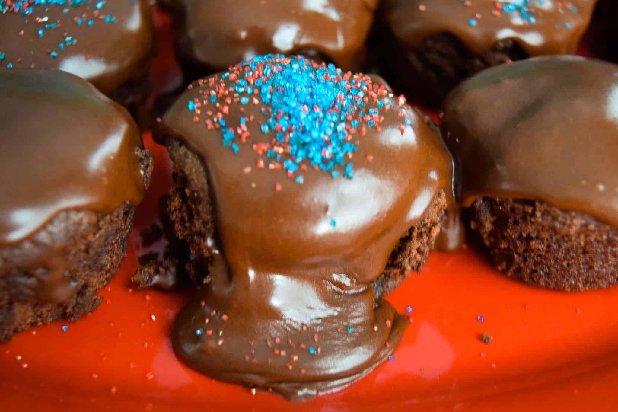 Chocolate Chip Brownie Bites with Homemade Icing oozing over the edge close up view