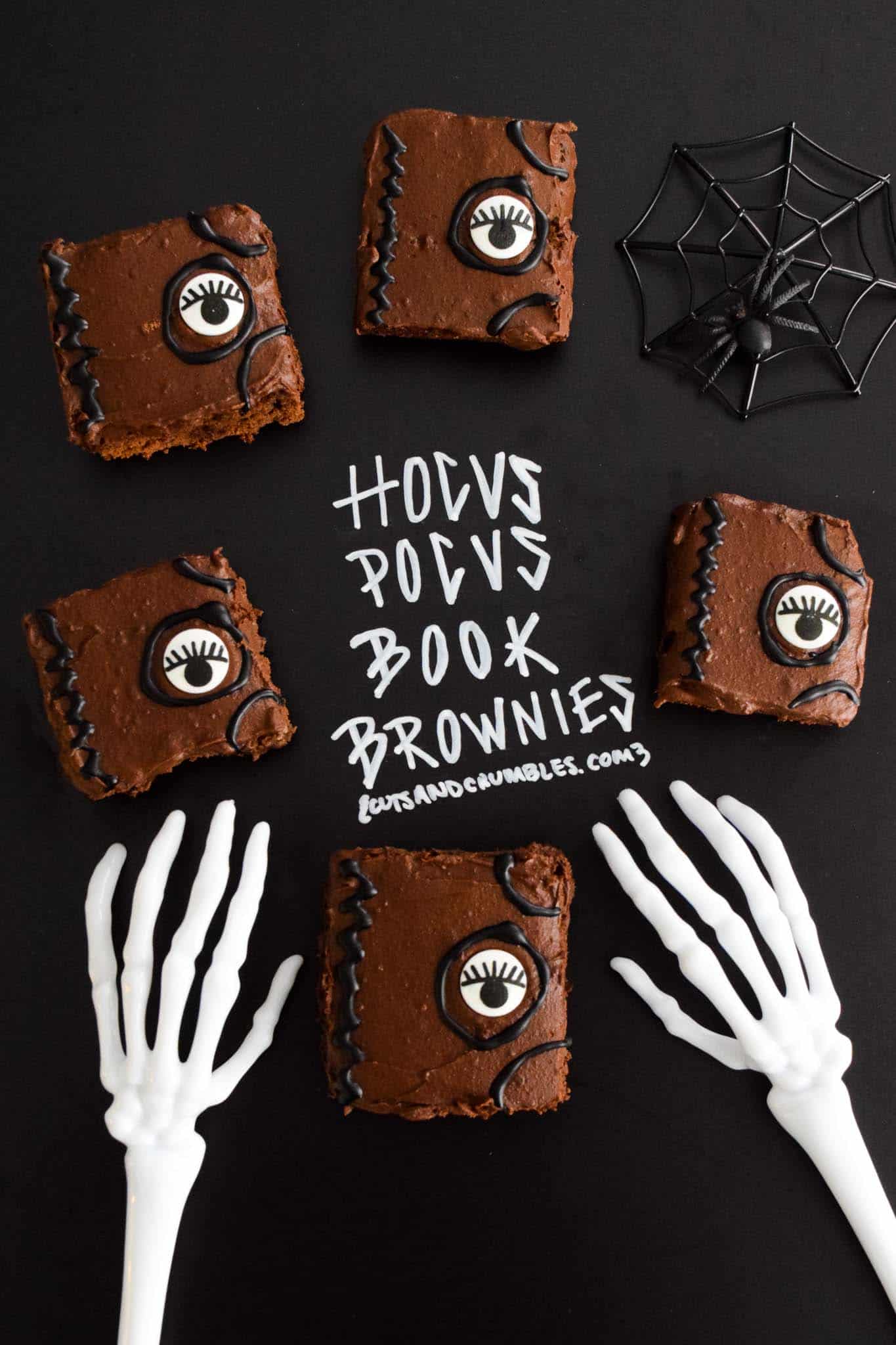Hocus Pocus Book Brownies with title written on chalkboard and halloween skeleton hands reaching for brownies