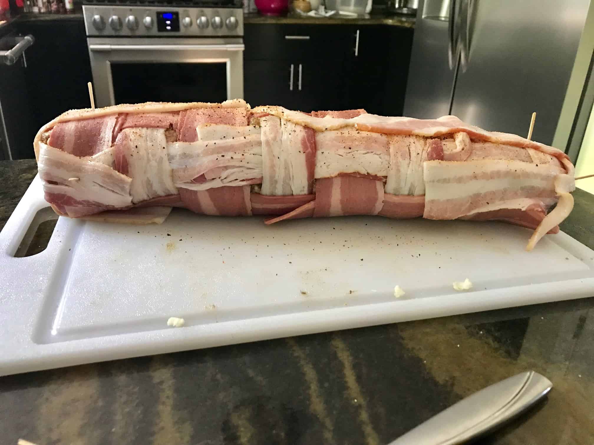 Rolled up bacon explosion on white cutting board side view