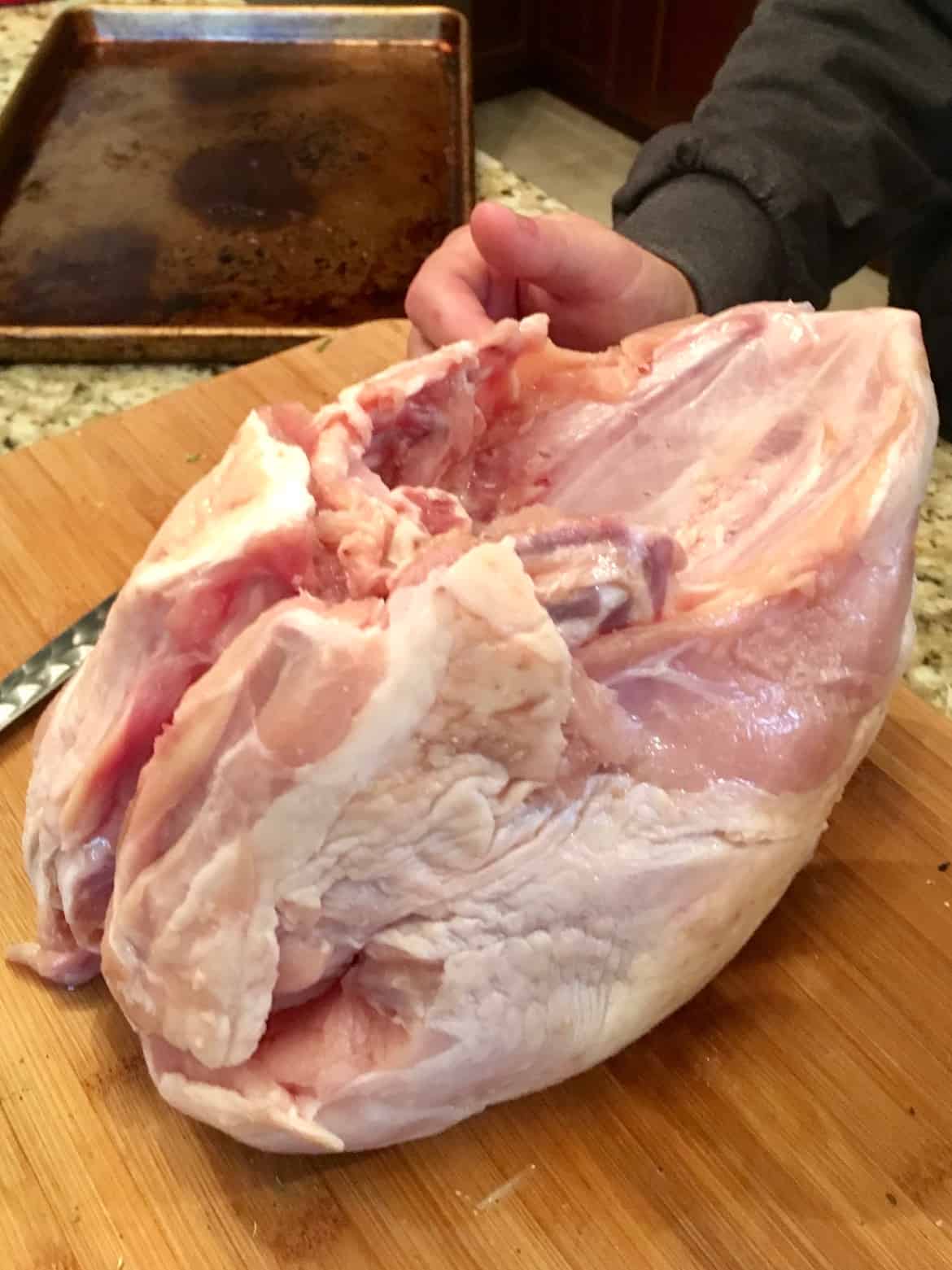 Raw turkey on wooden cutting board ready to be deboned