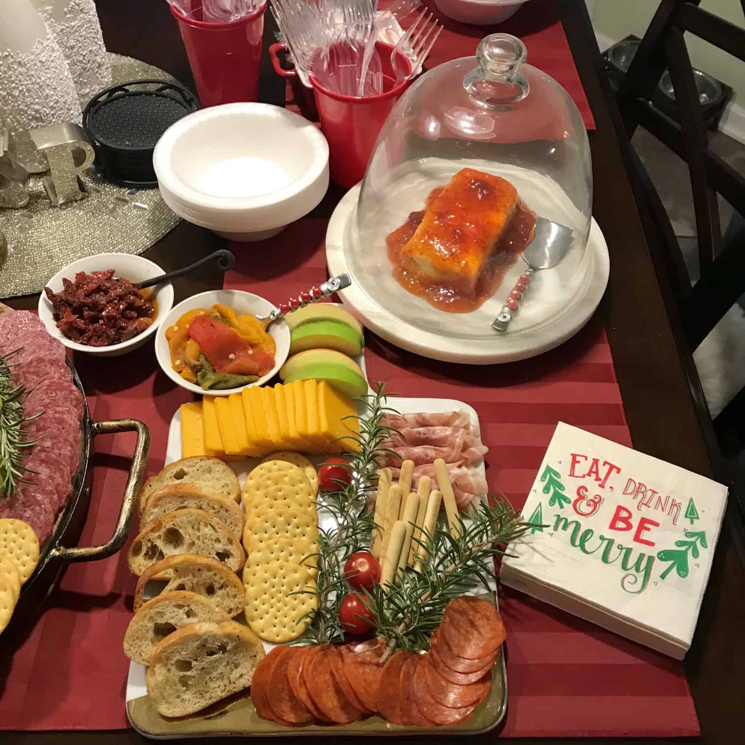 Holiday Cheese Board with pepper jelly in background and festive napkins in front