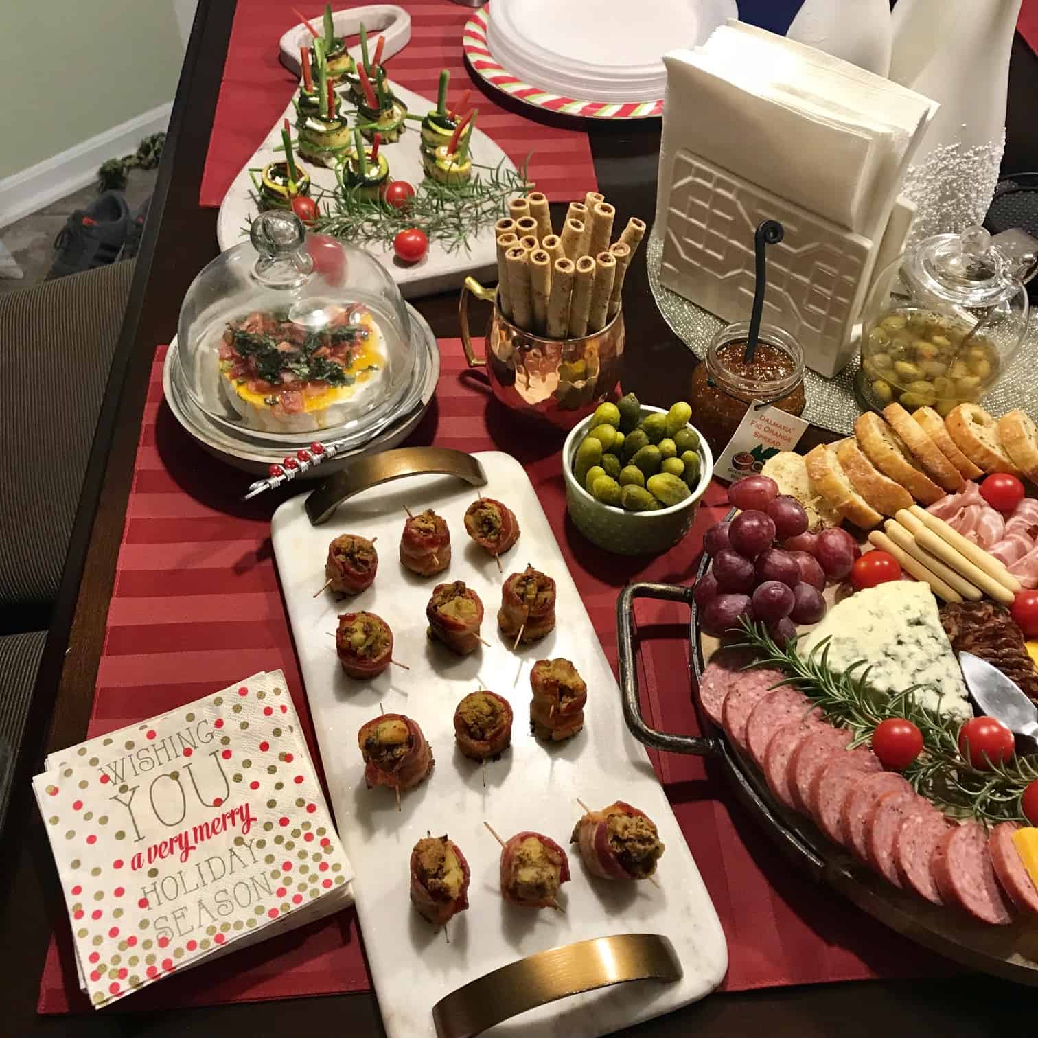 Festive holiday spread with various appetizers and holiday napkins