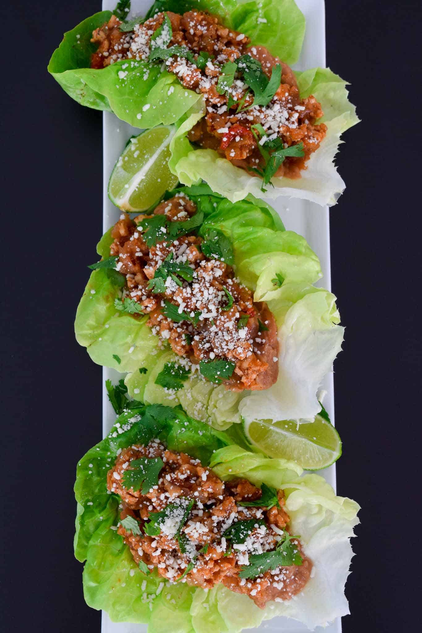 Chicken Tacos in Lettuce Wraps on white platter ready to be served overhead shot