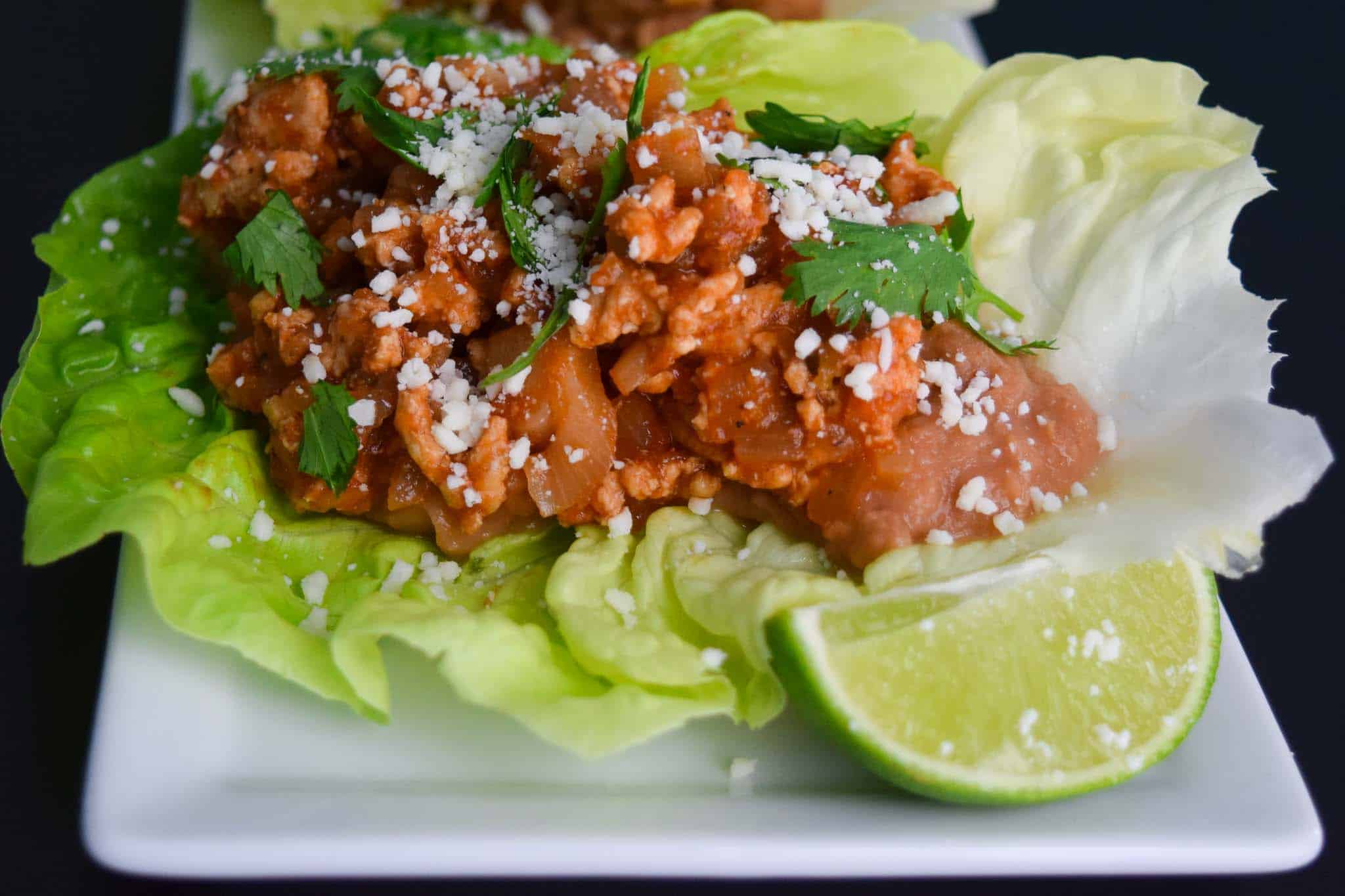 Chicken Taco in Lettuce Wraps on white platter close up view