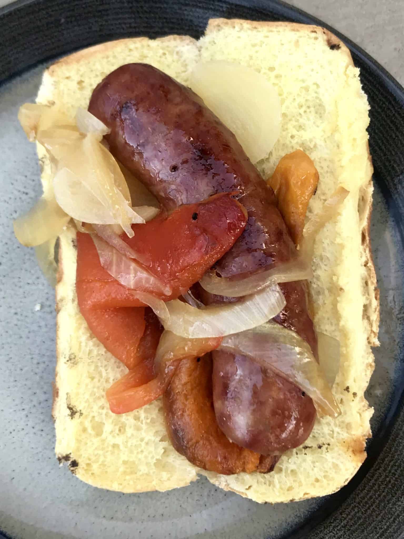 Sausage and Peppers on hot dog bun ready to be eaten overhead shot