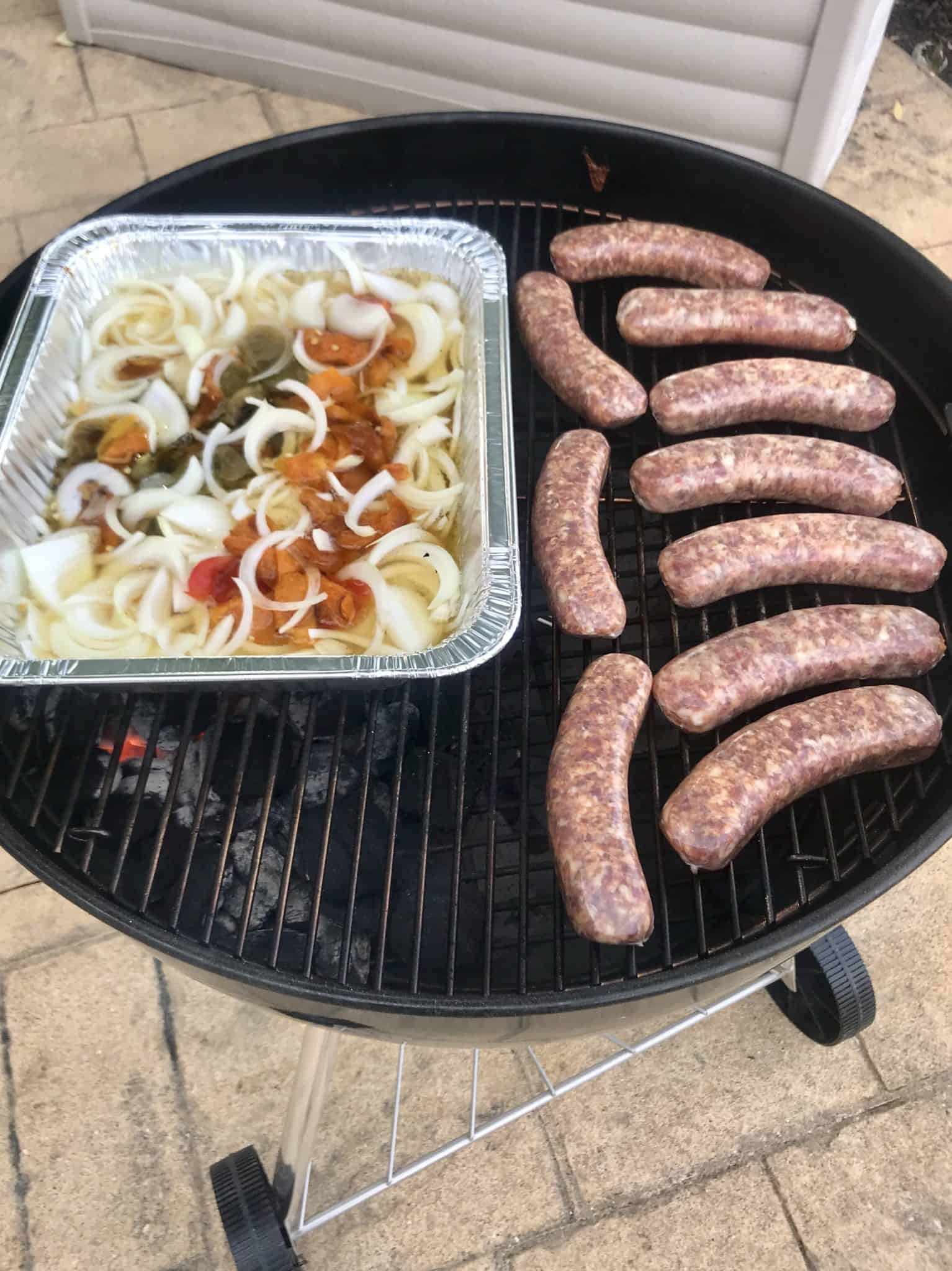 Sausage and Peppers uncooked on weber grill side view