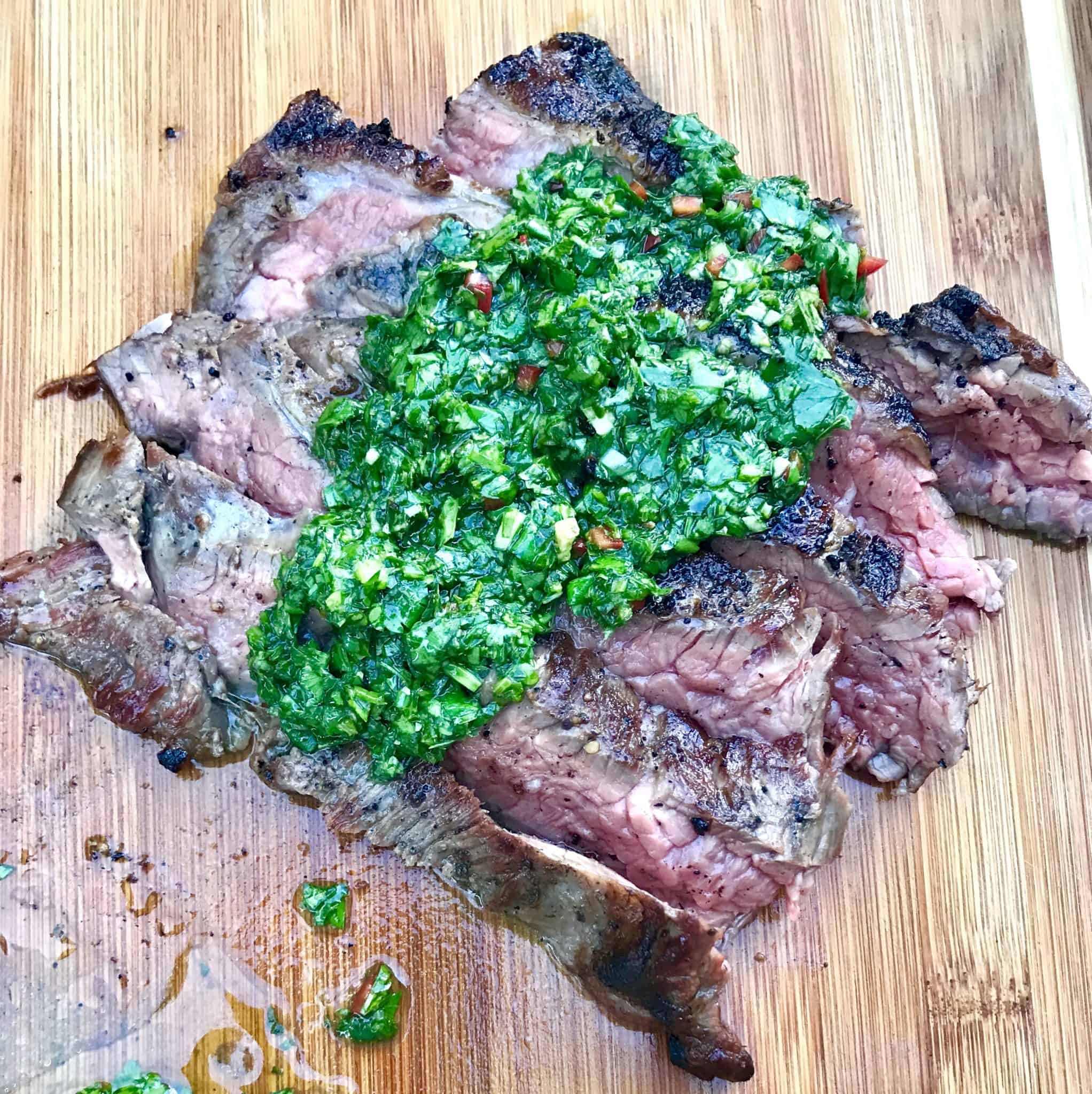 Bright green Chimichurri Sauce on top of steak overhead shot