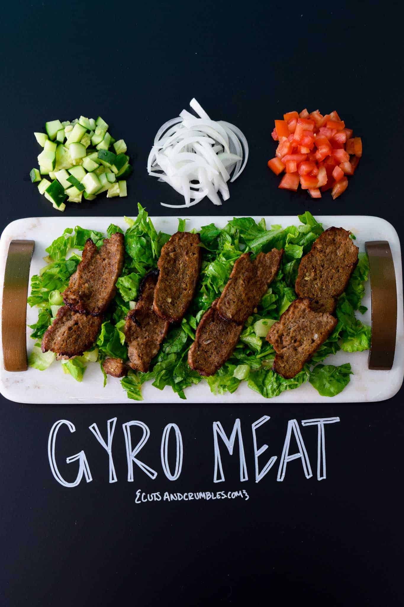 Gyro Meat on white platter with title written on chalkboard 