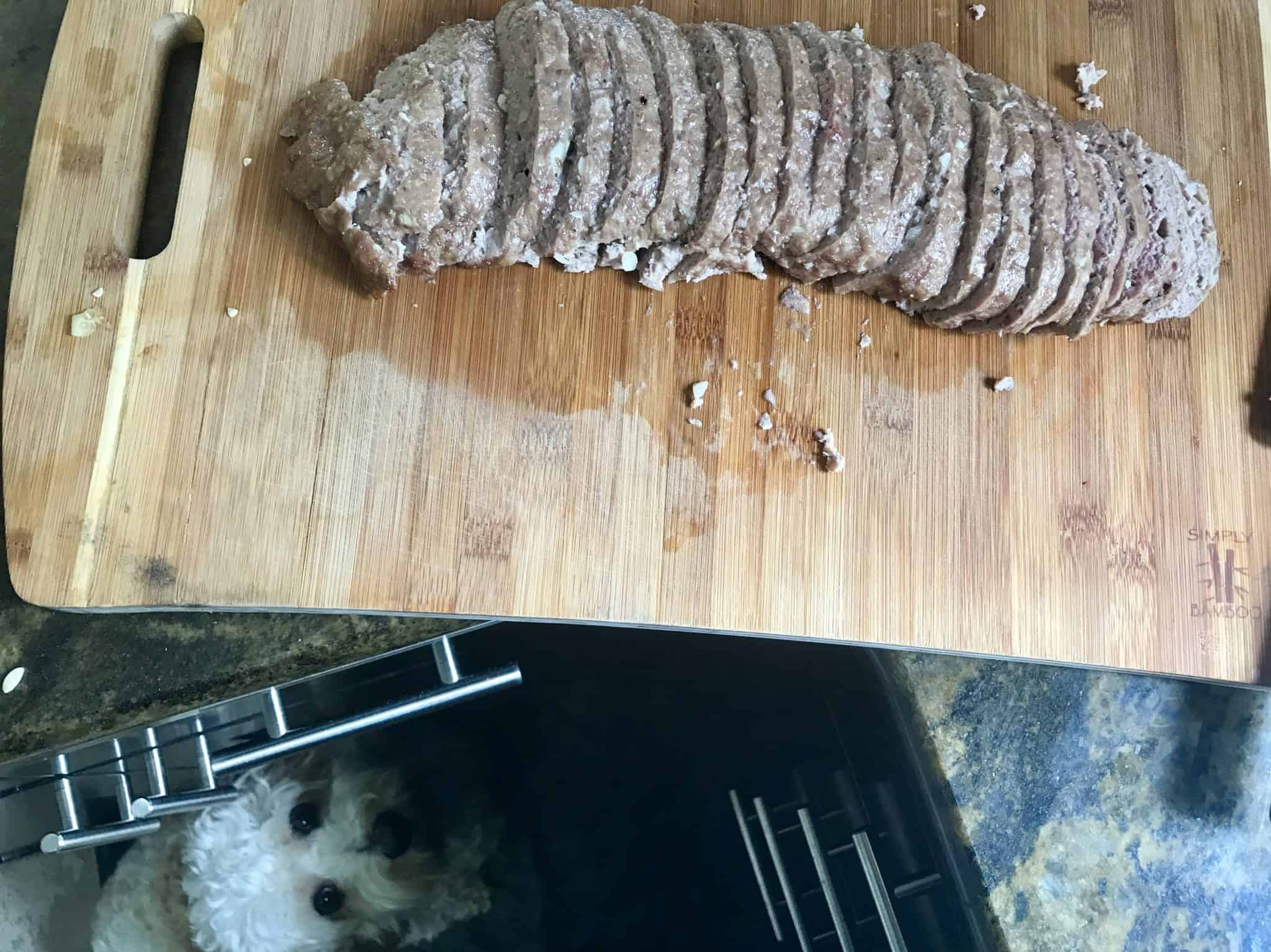 Gyro Meat sliced on cutting board with dog eyeing it